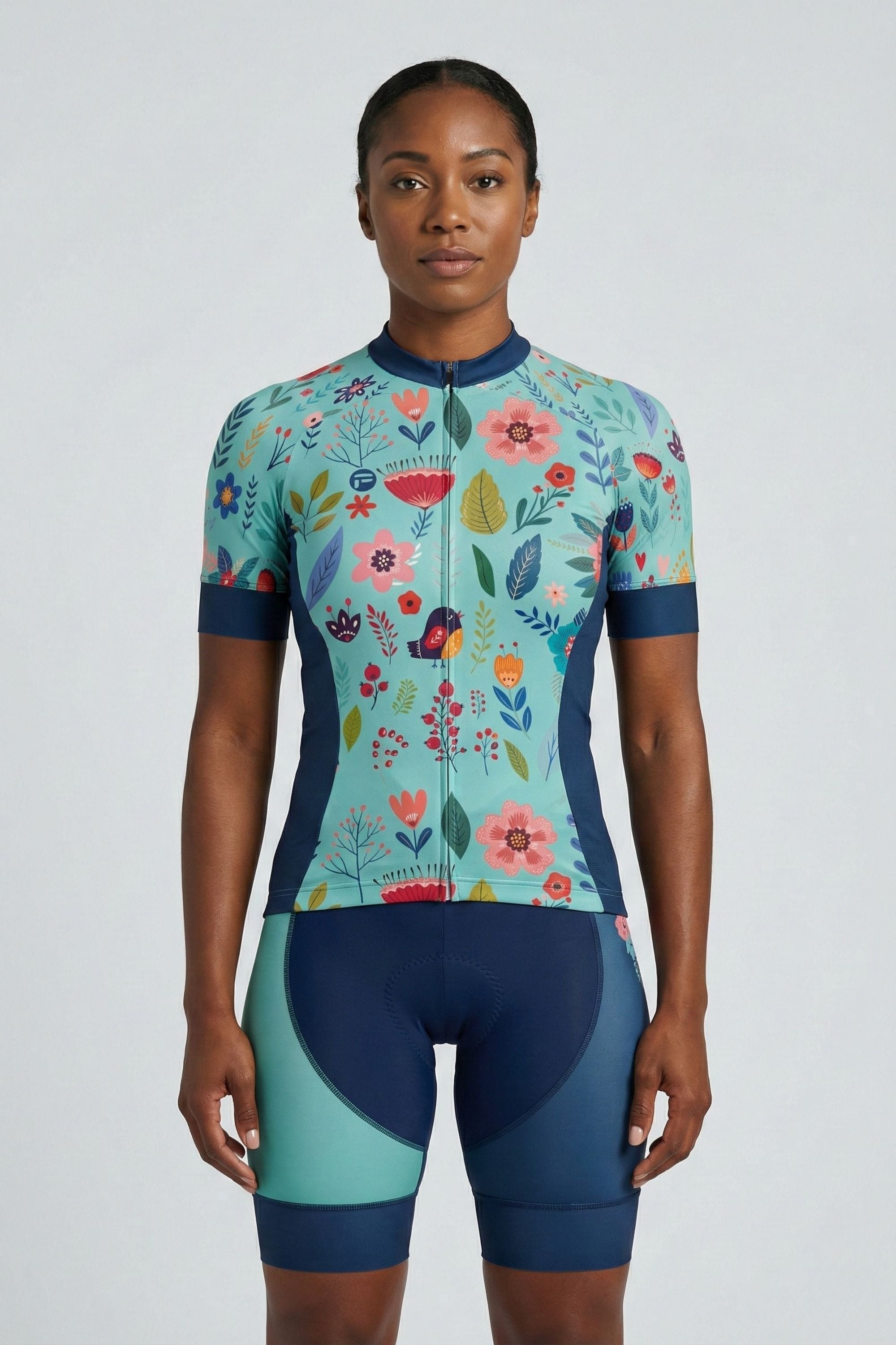 Person wearing a blue cycling outfit with flowers on a plain background by Cycling Frelsi