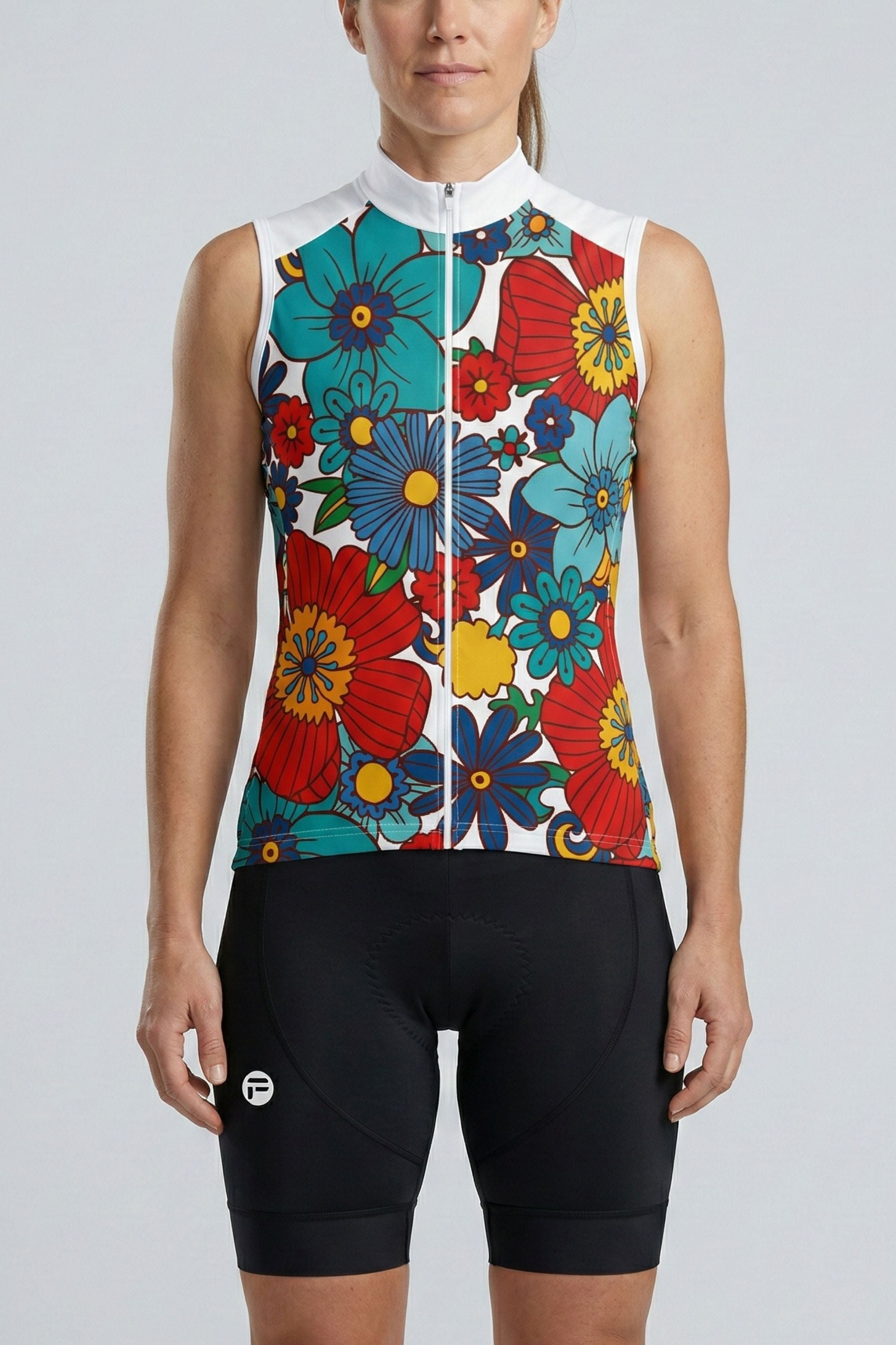 Woman wearing a colorful floral sleeveless cycling outfit on a gray background