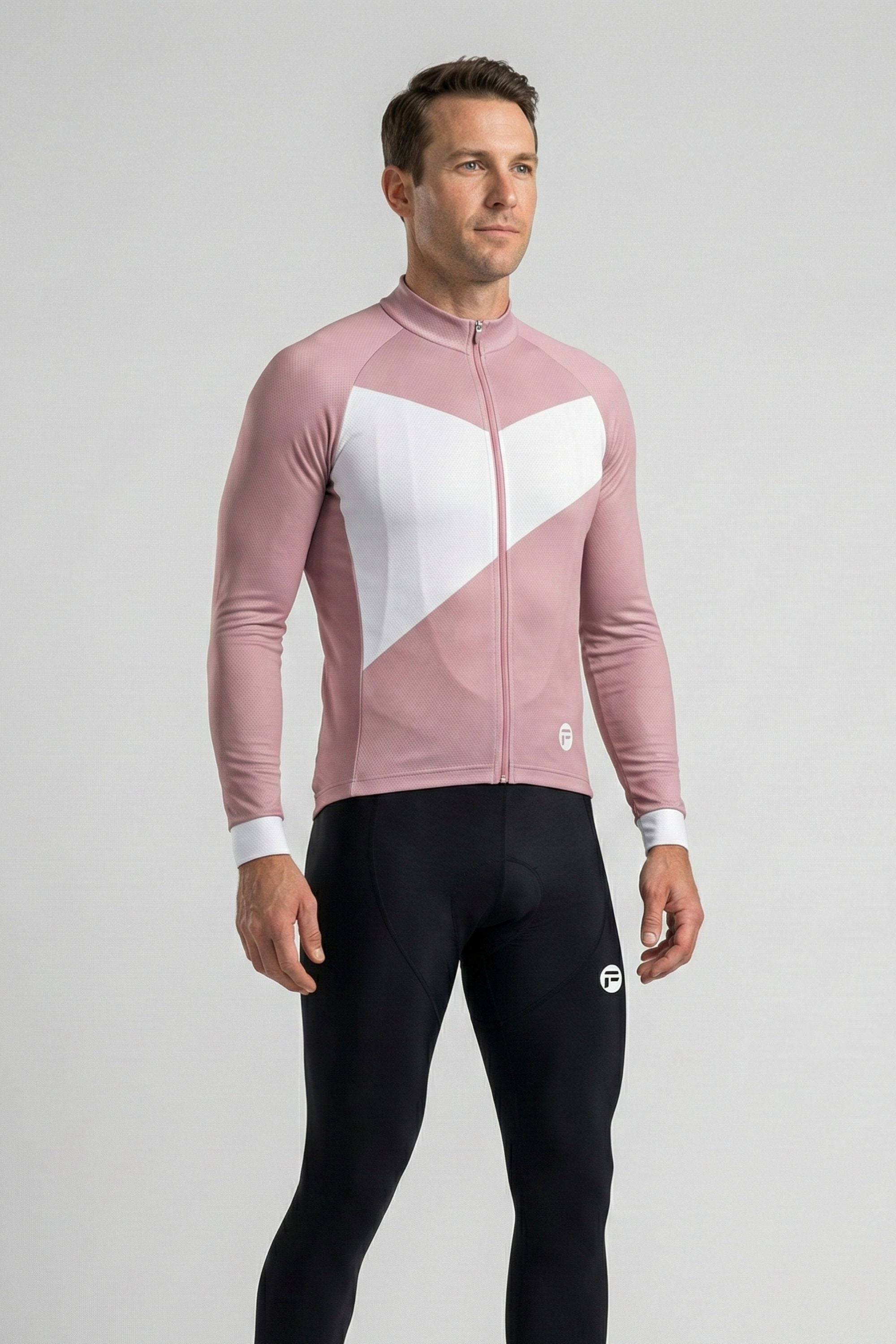 Man wearing a pink and white cycling jersey with black pants on a gray background
