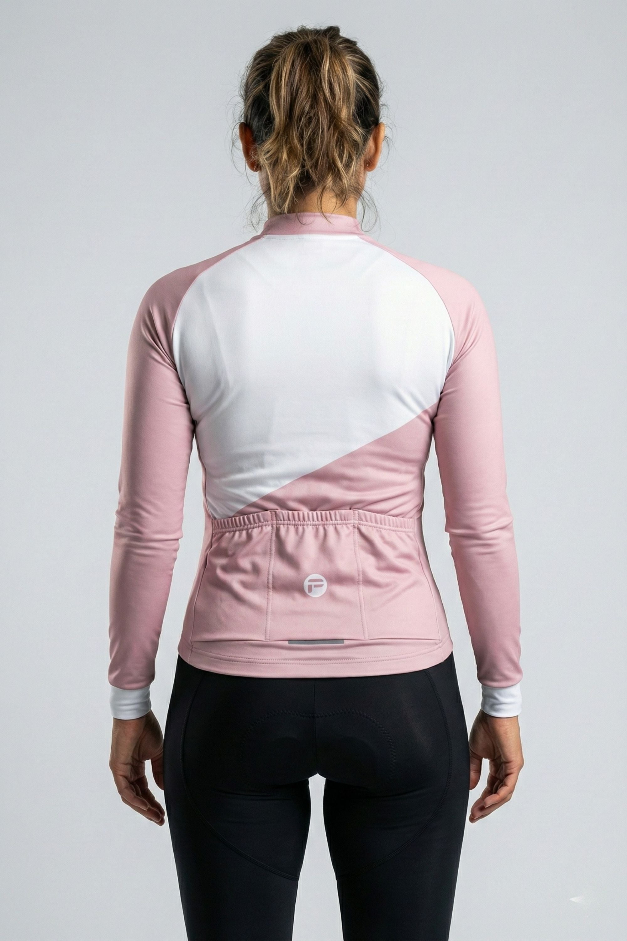 Person wearing a pink and white cycling outfit on a plain background by Cycling Frelsi