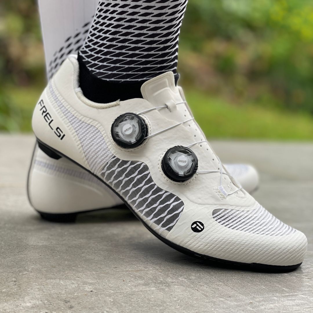 A cyclist wearing a white Frelsi Pro Carbon Shoe, emphasizing a sleek and aerodynamic design