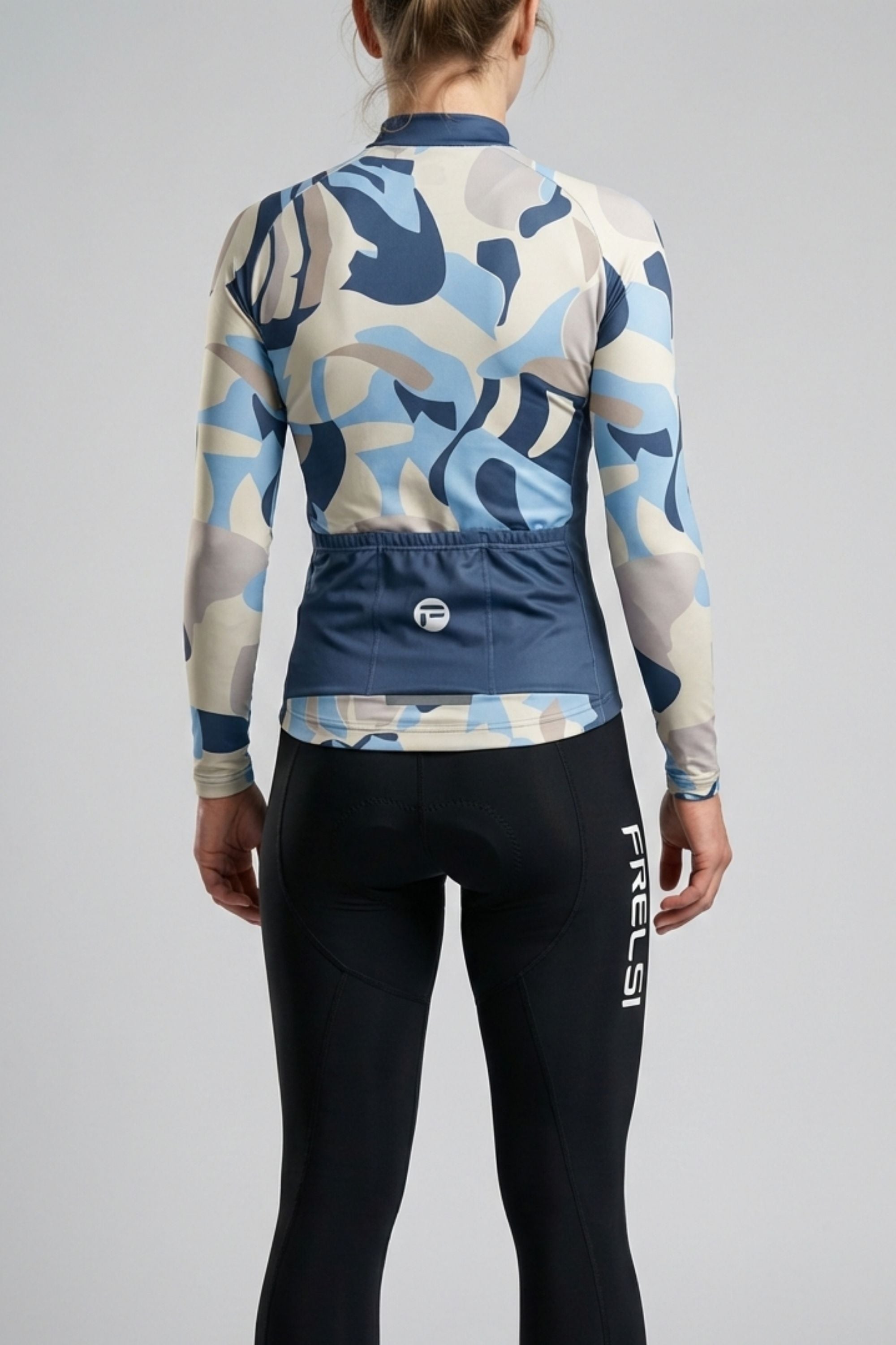 Person wearing a white cycling outfit with blue and yellow stripes on a plain background by Cycling Frelsi