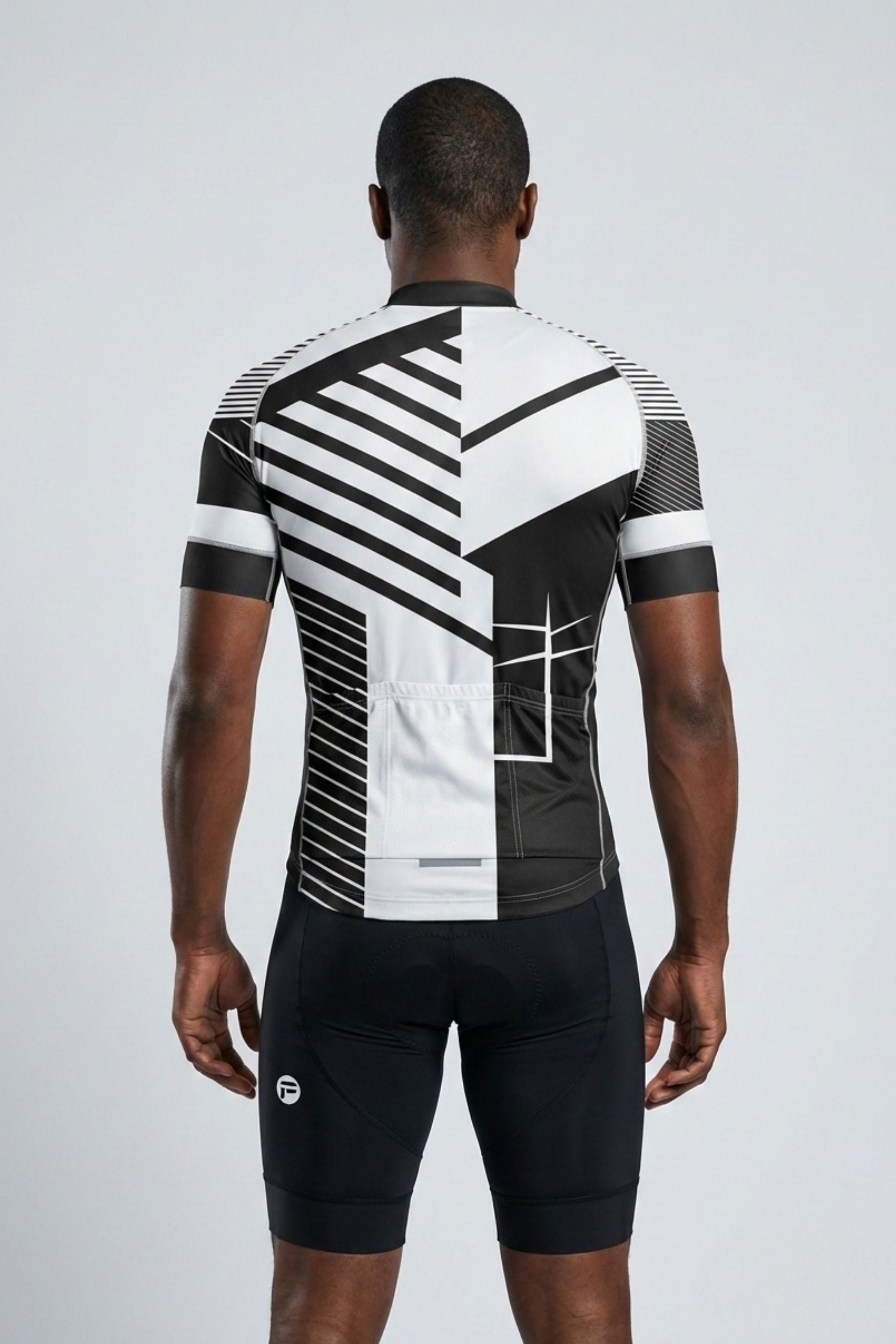 Person wearing a black and white cycling outfit with geometric patterns on a gray background