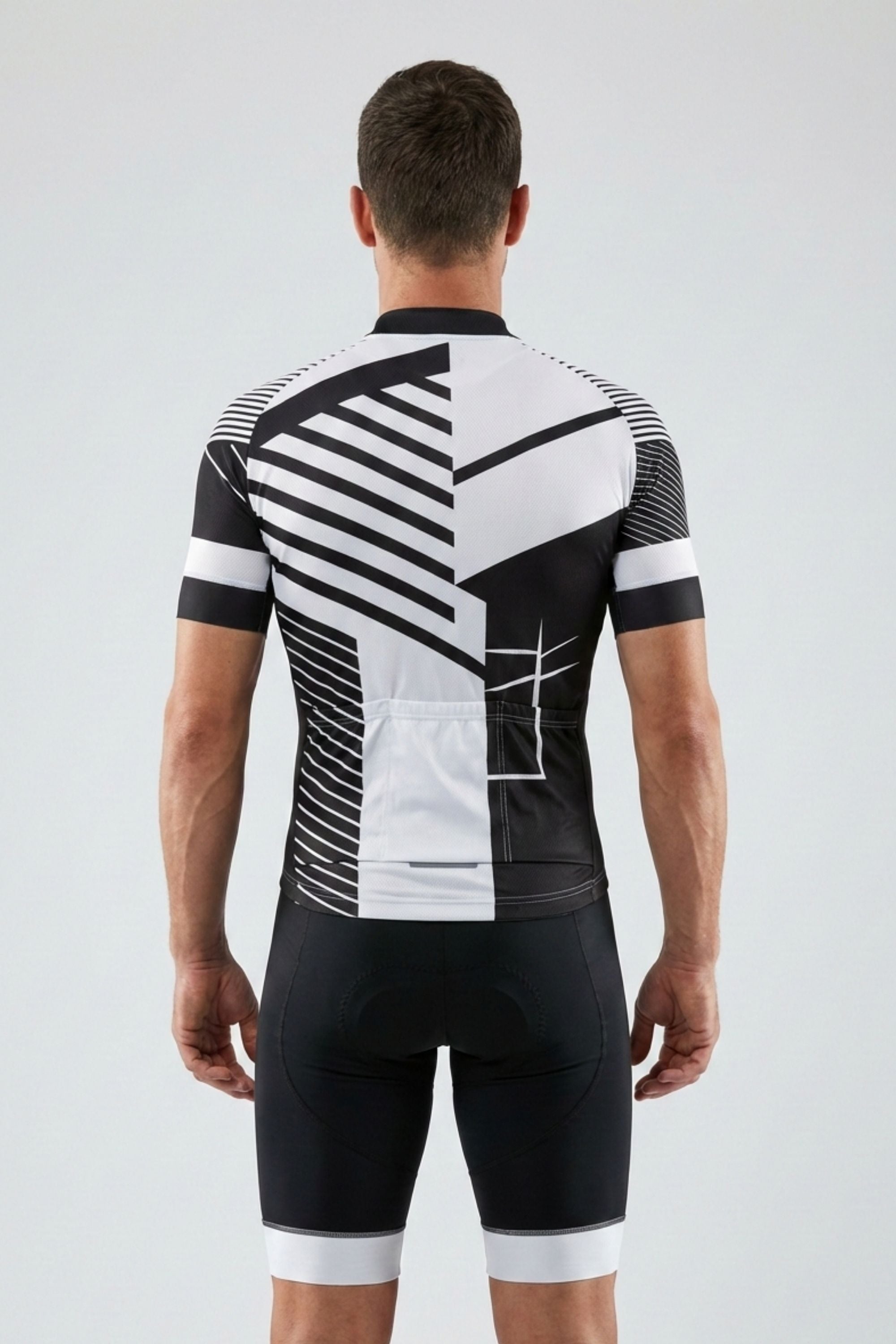 Person wearing a black and white cycling outfit with geometric pattern on a light gray background