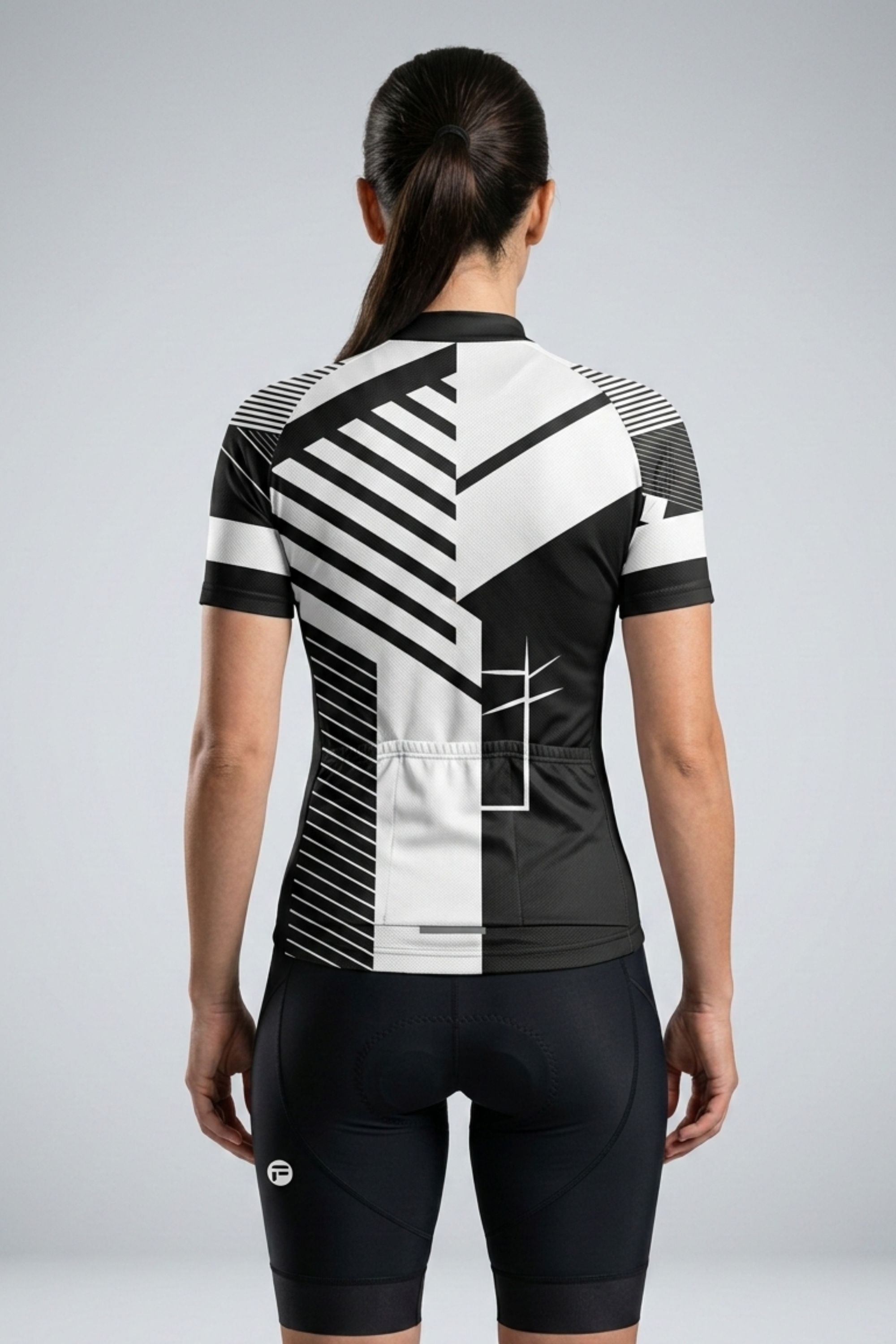 Person wearing a black and white cycling outfit with geometric patterns on a gray background
