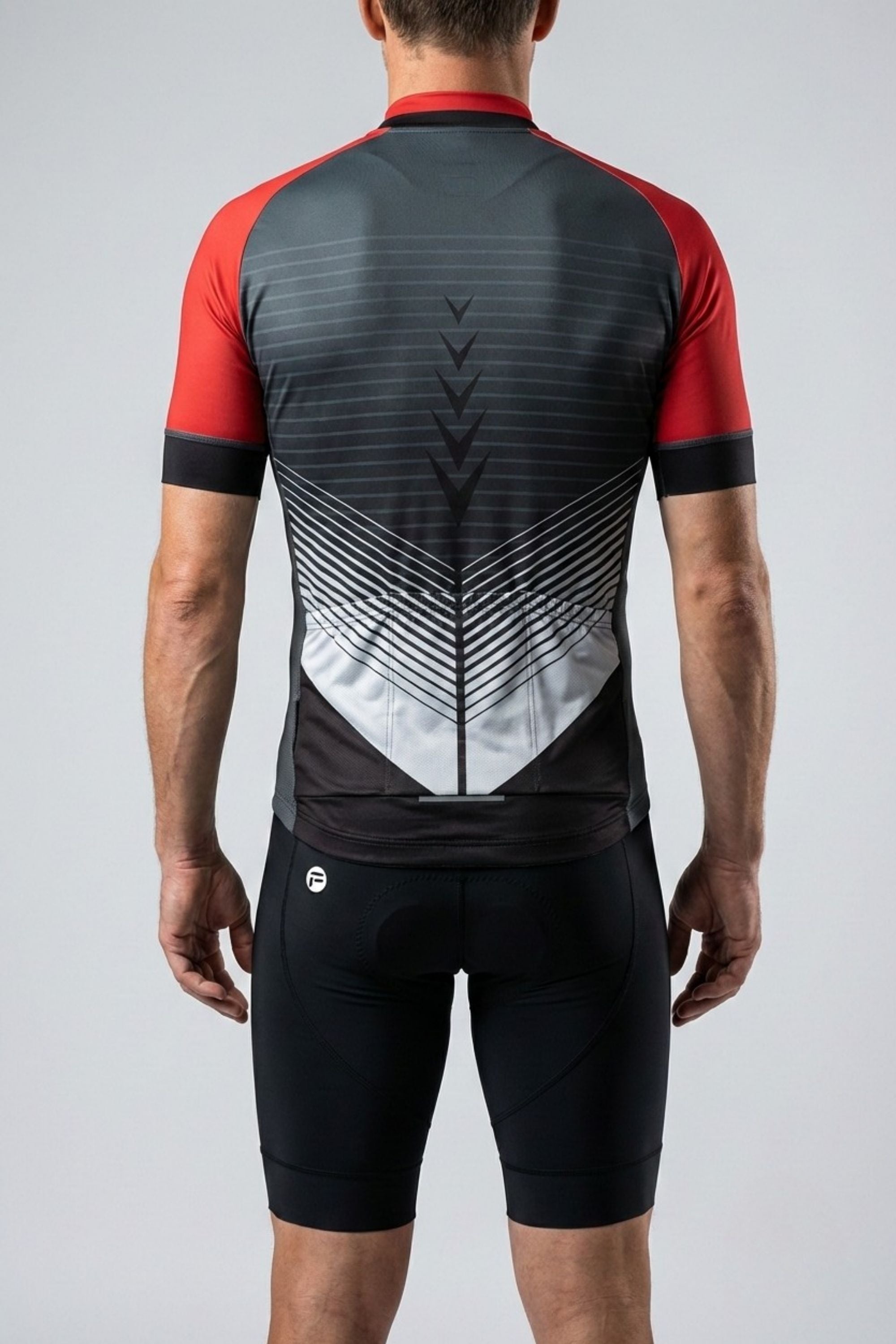 Person wearing a black and red cycling outfit with geometric design on a gray background