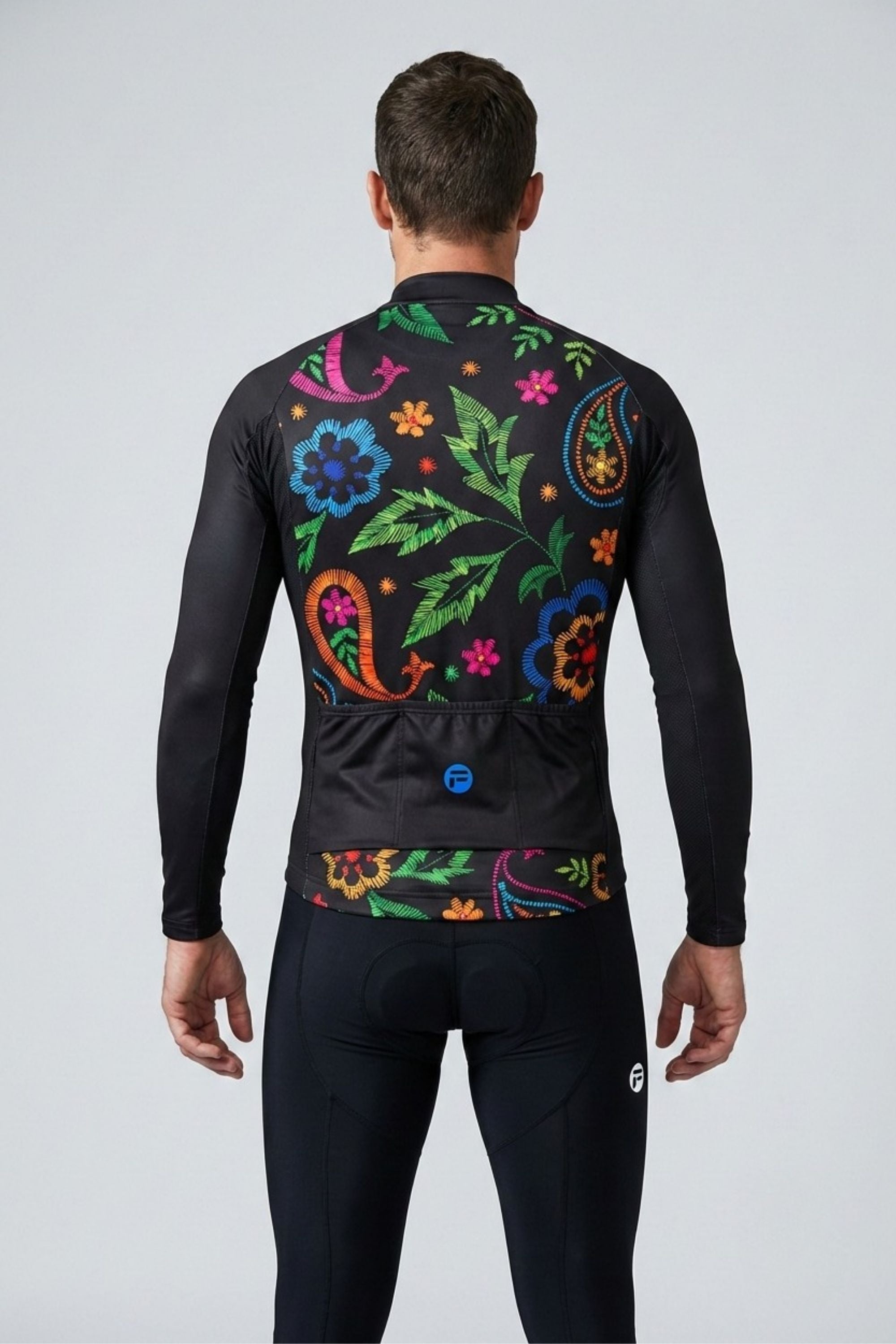 Person wearing a black cycling jersey with colorful floral patterns on the back against a white background