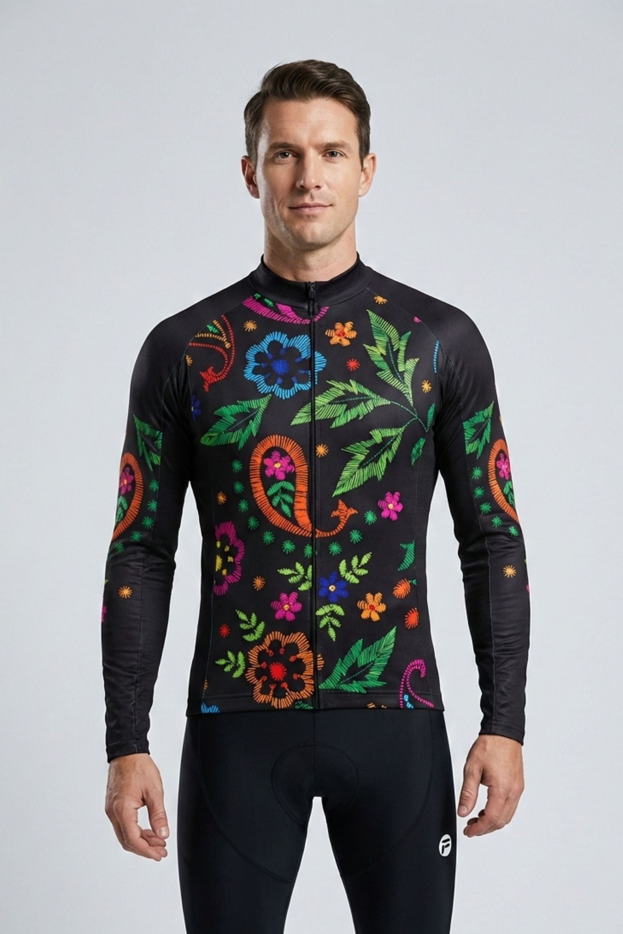 Man wearing a black cycling jersey with colorful floral patterns on a light gray background