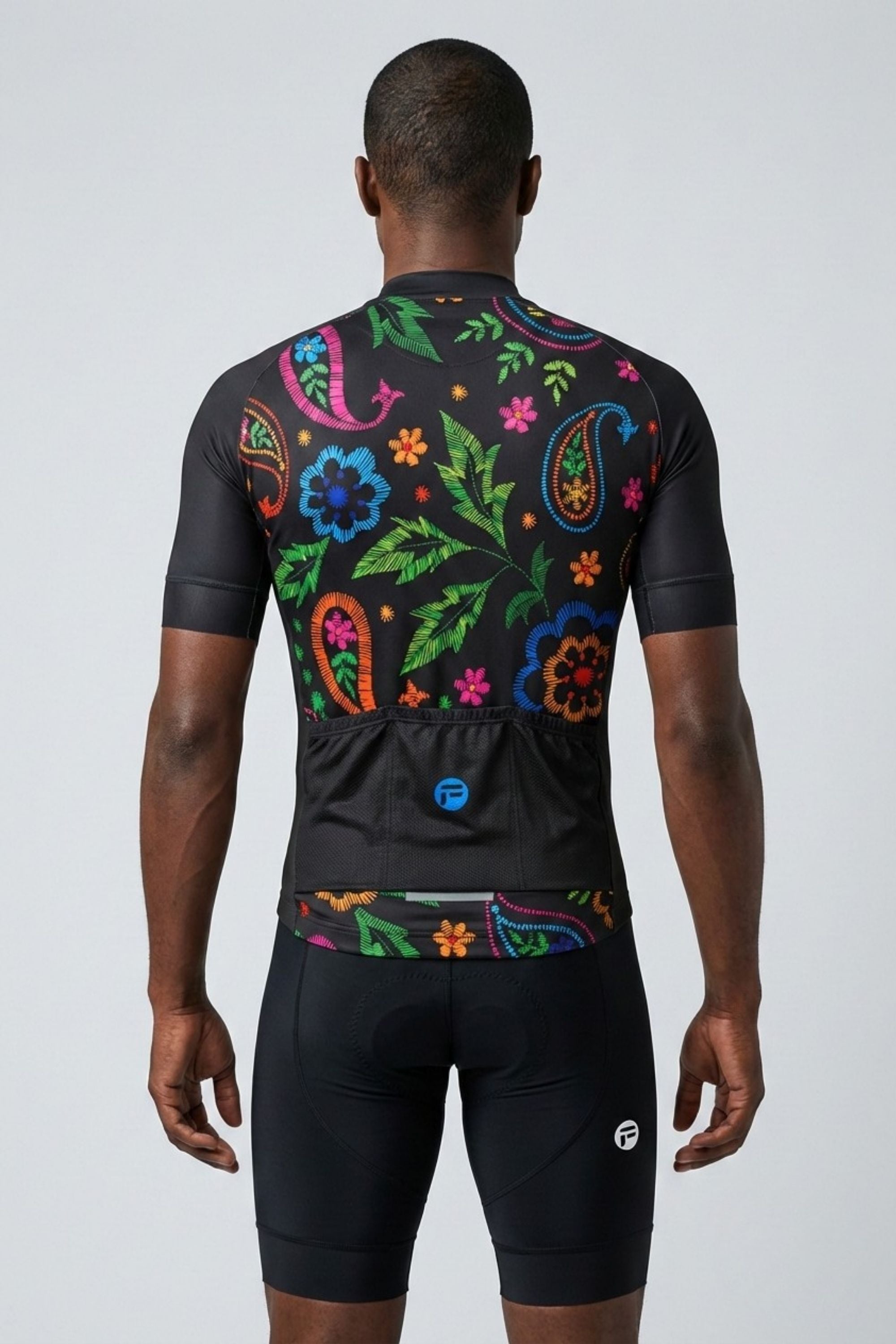 Person wearing a black cycling outfit with colorful floral patterns on the back against a white background