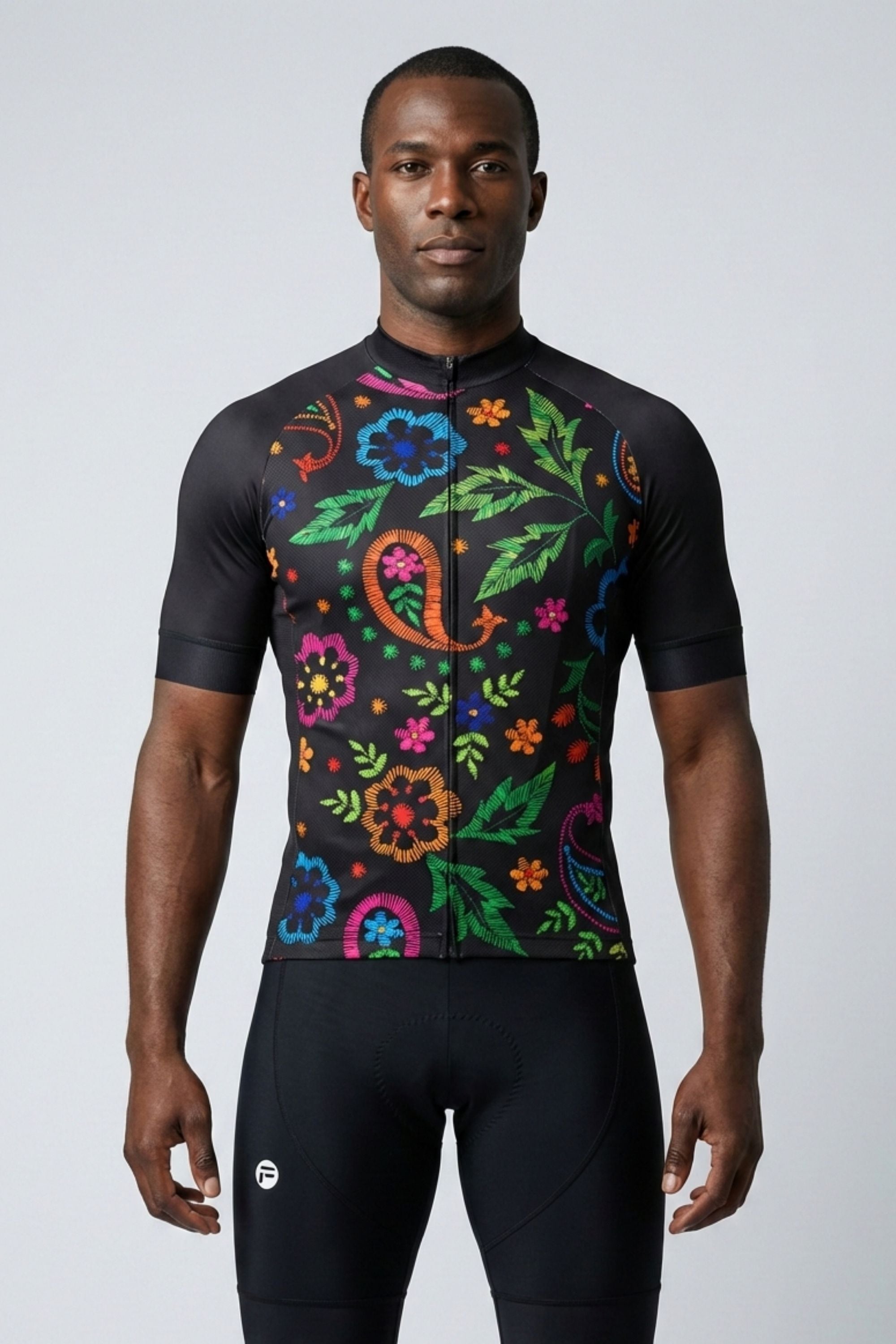 Man wearing a black cycling jersey with colorful floral patterns on a white background
