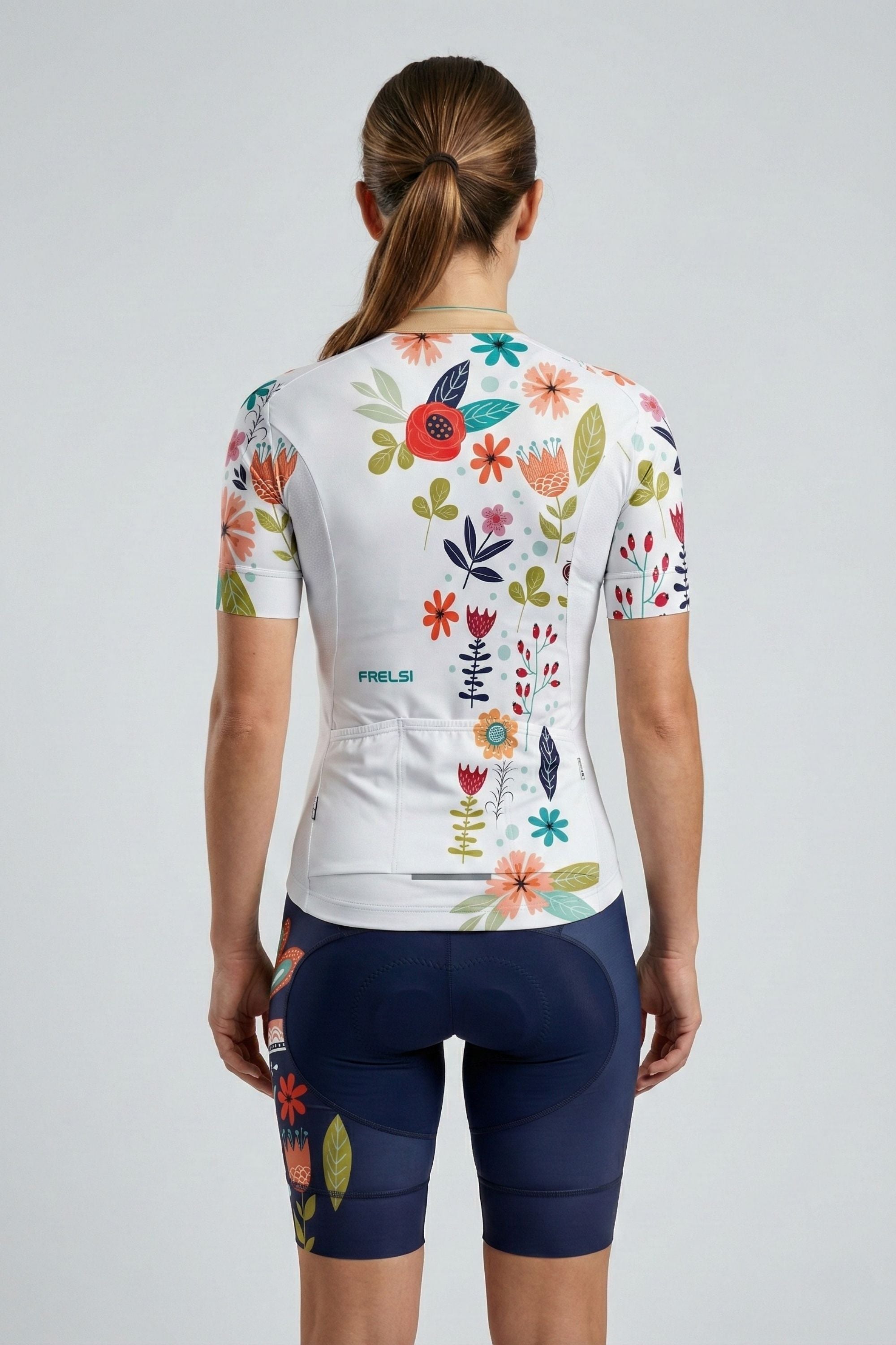 Person wearing a white cycling outfit with blue bird on a plain background by Cycling Frelsi