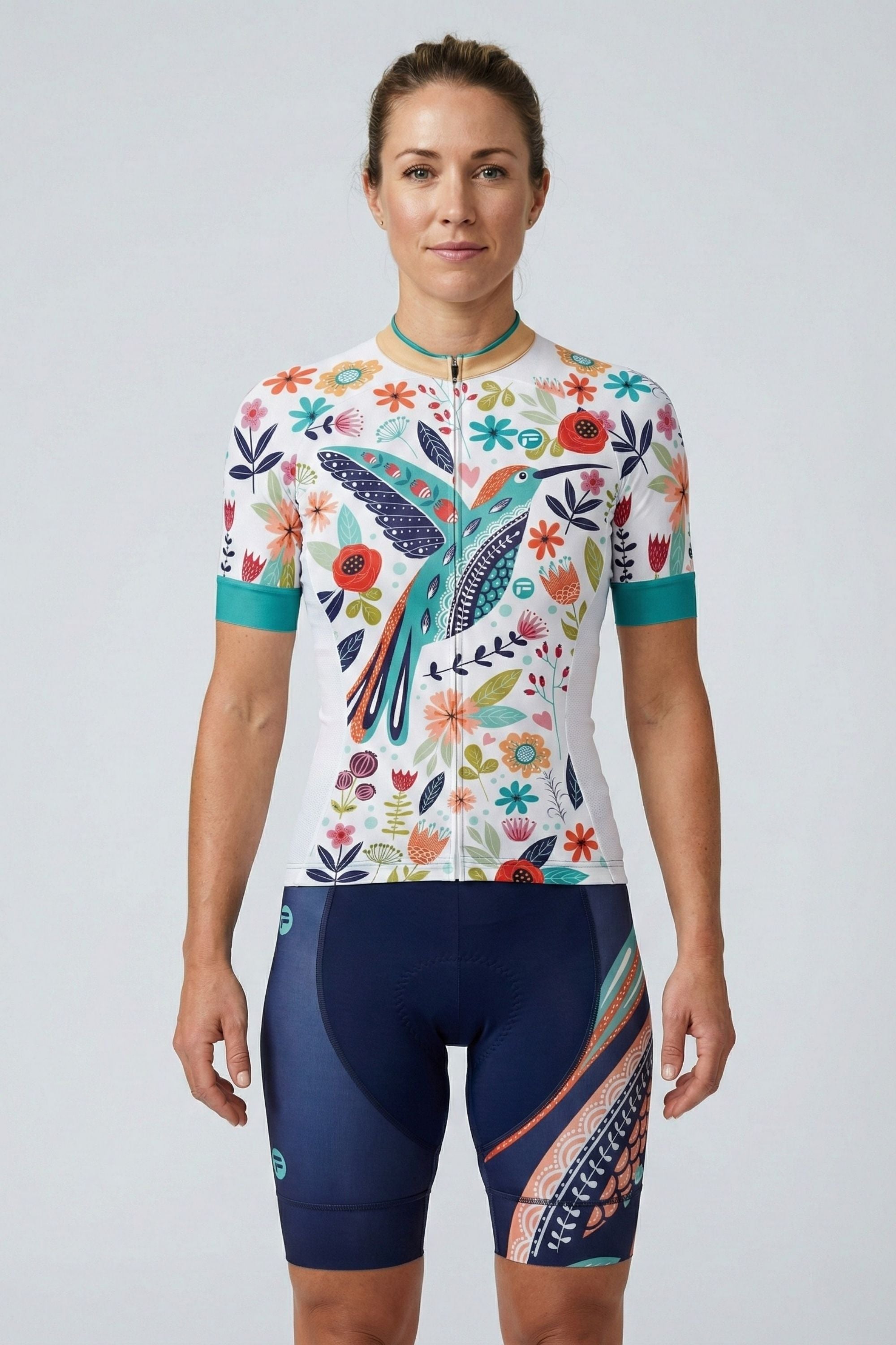 Person wearing a white cycling outfit with blue bird on a plain background by Cycling Frelsi
