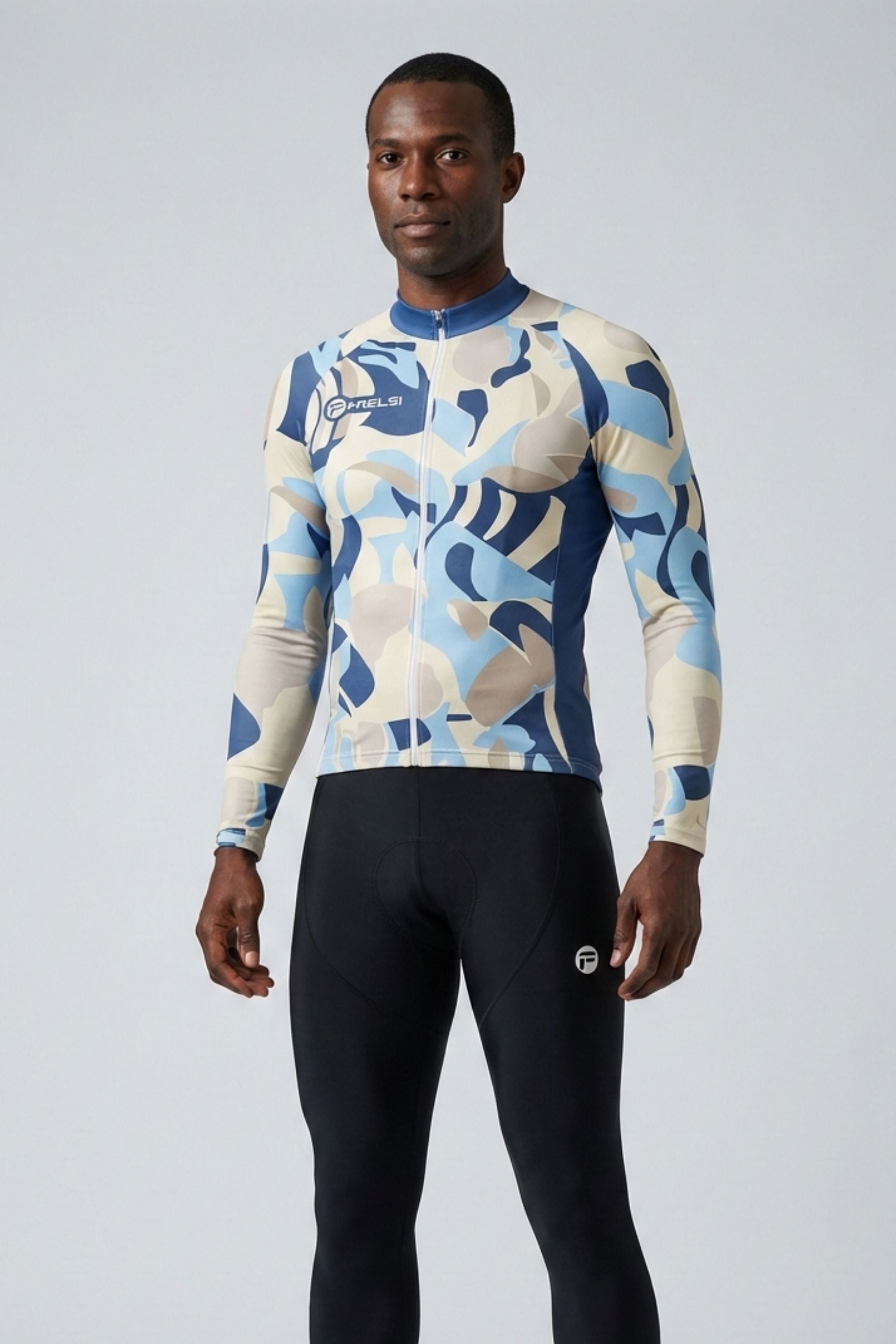 Person wearing a patterned long-sleeve shirt and black pants on a light gray background