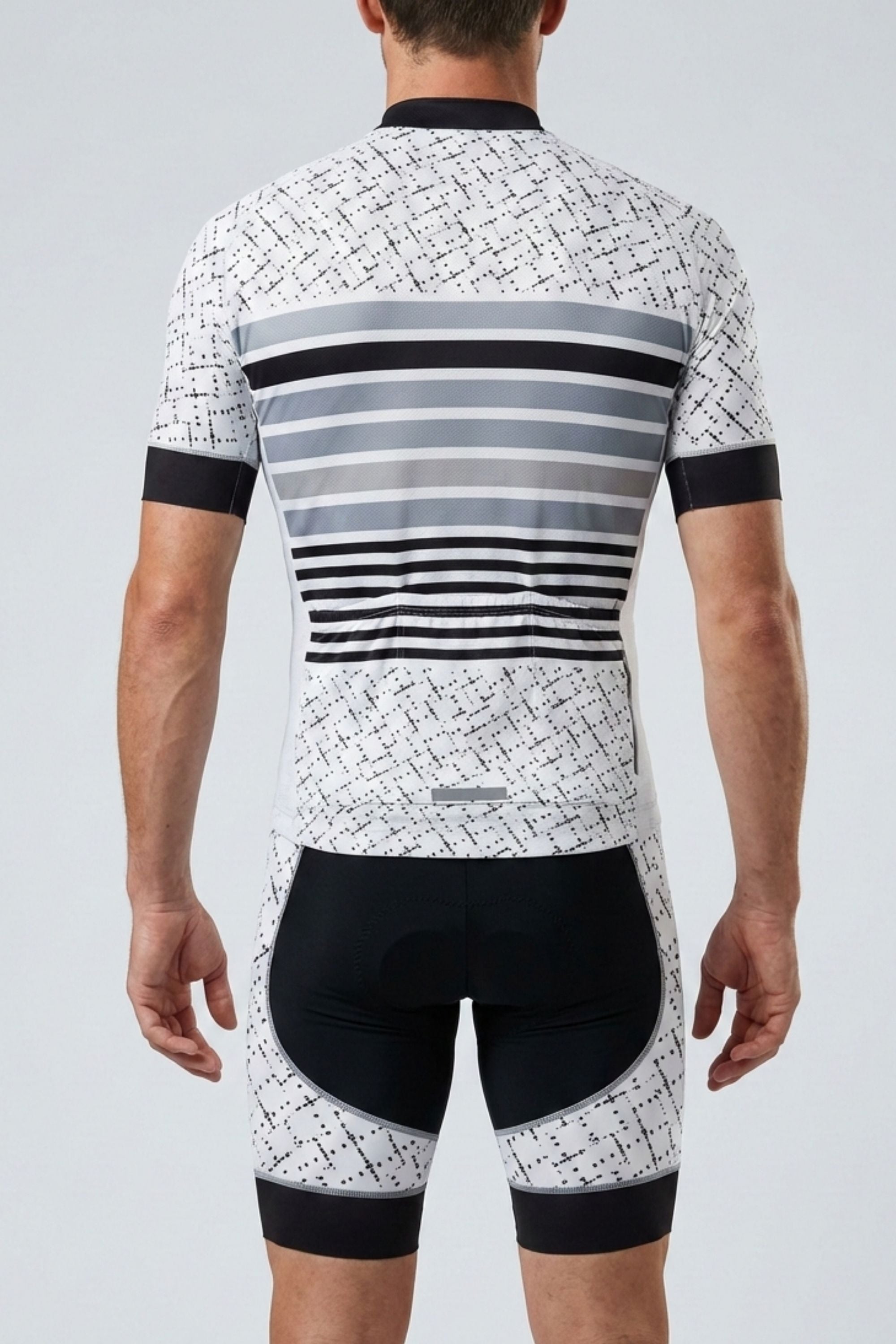 Cycling outfit with a patterned jersey and black shorts on a gray background