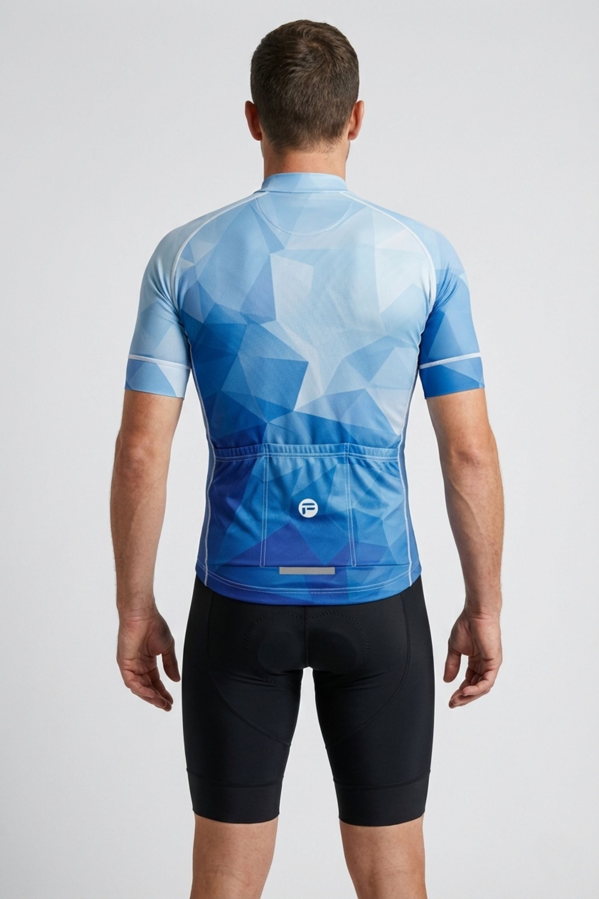 Person wearing a blue geometric patterned cycling jersey and black shorts on a light gray background