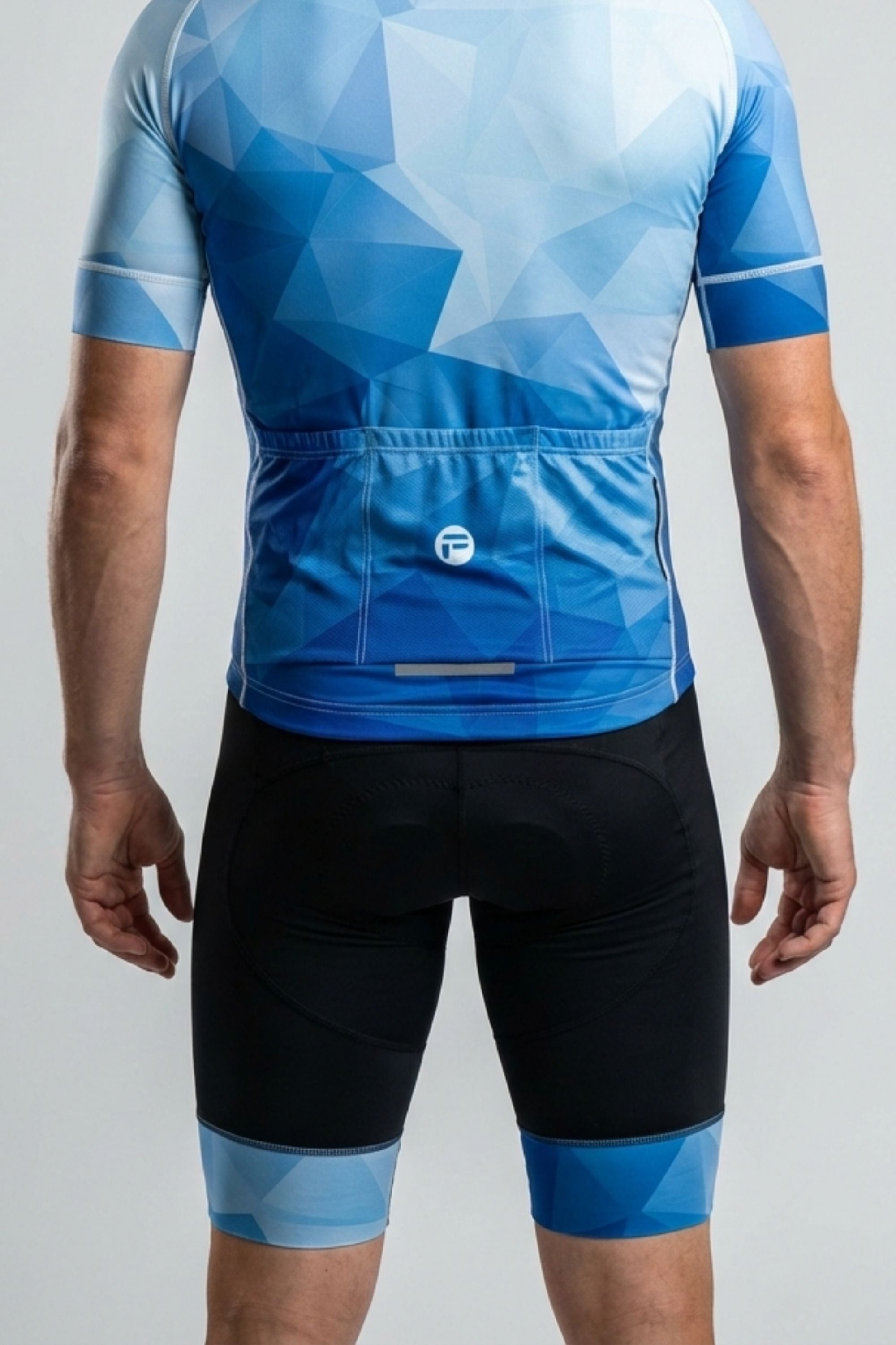 Person wearing a blue cycling jersey and shorts on a gray background