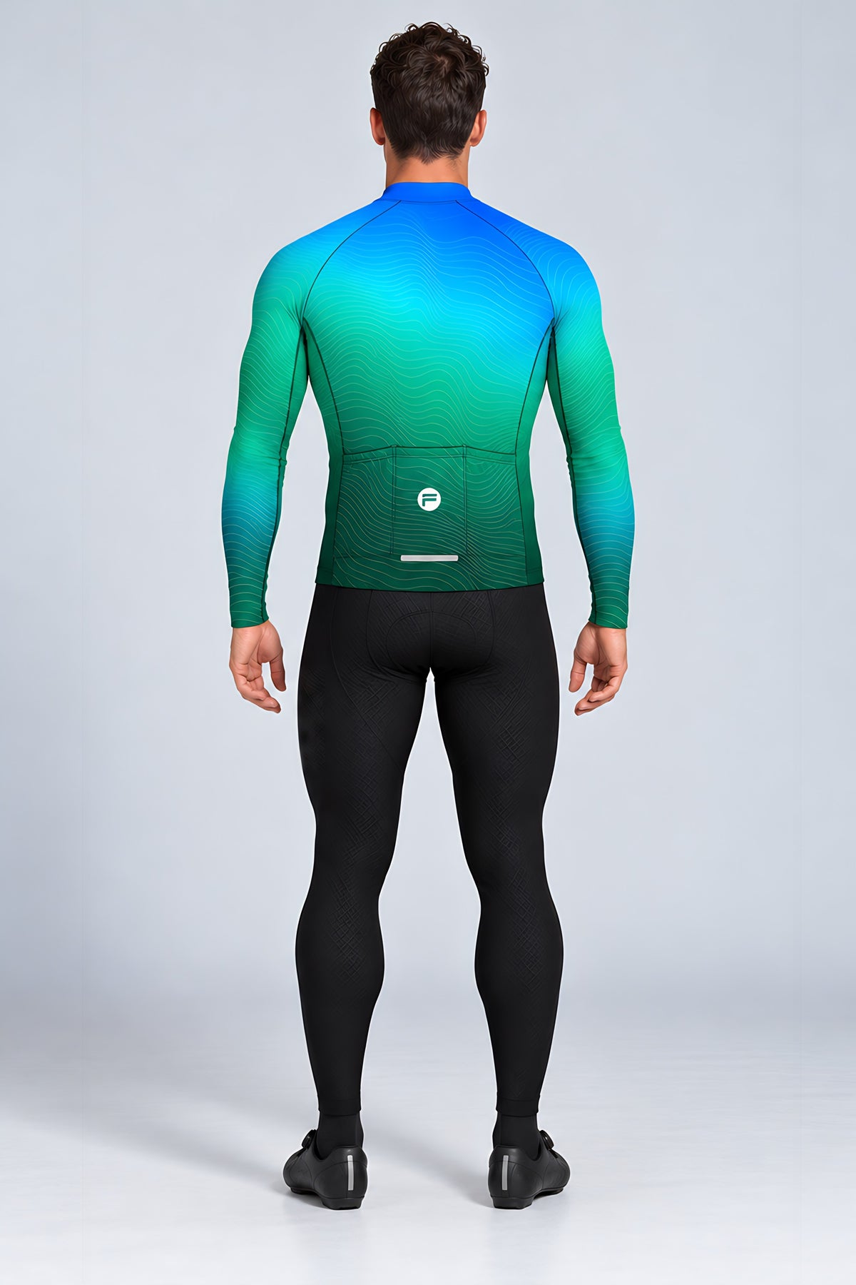 Man wearing the Ocean Pulse long sleeve cycling jersey with black bib tights - back view