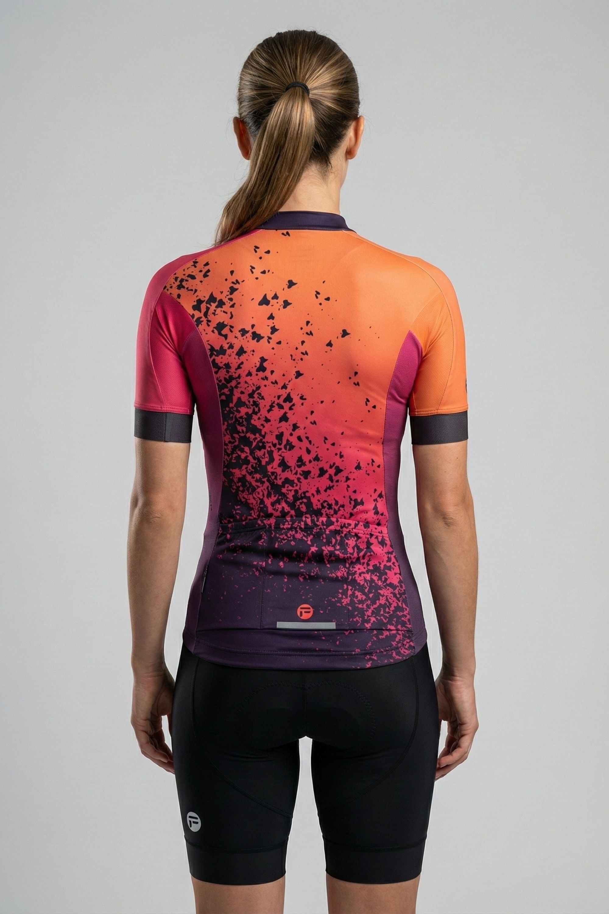 Person wearing a colorful cycling outfit with a gradient design on a plain background by Cycling Frelsi