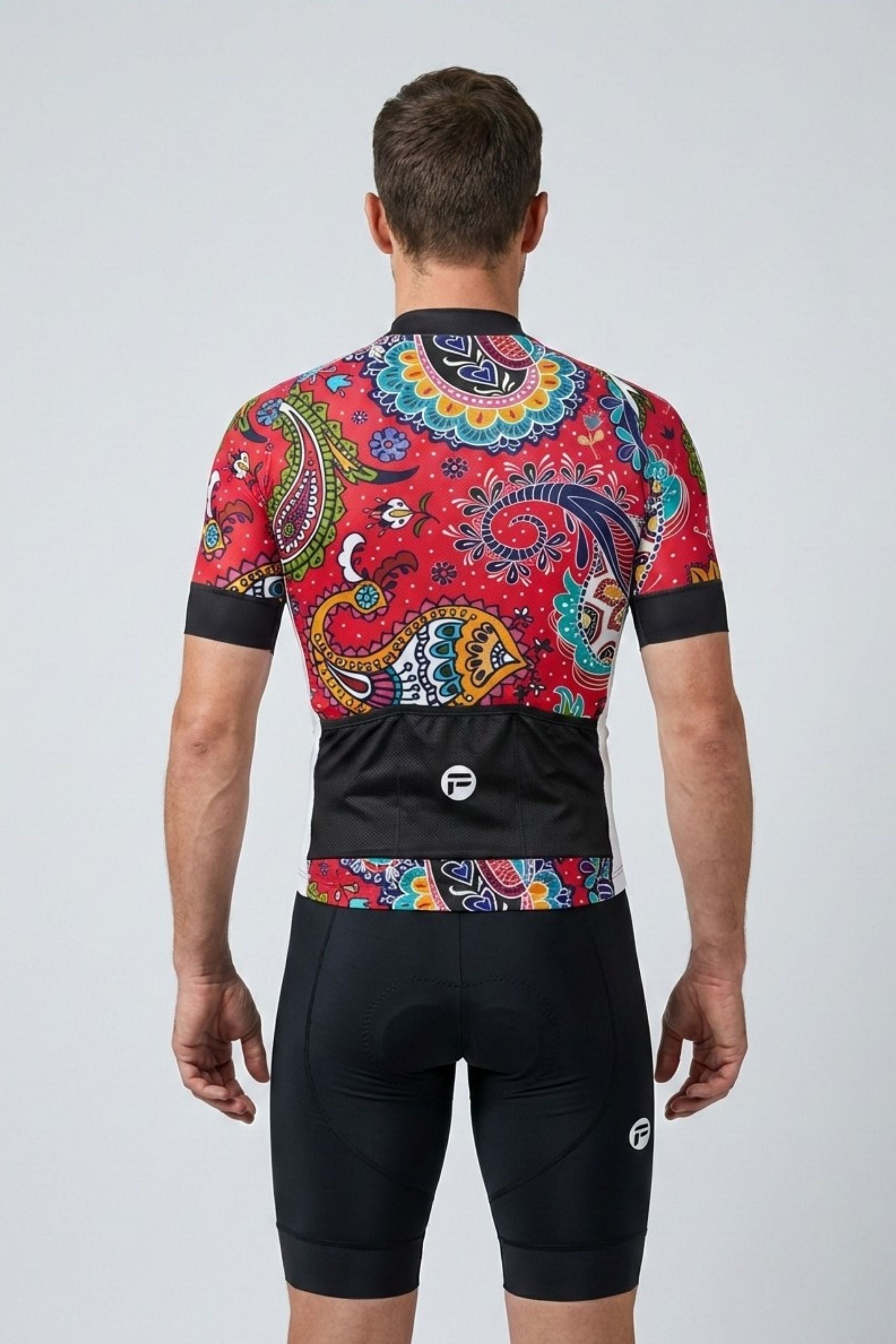 Cyclist wearing a colorful cycling jersey and black shorts on a white background