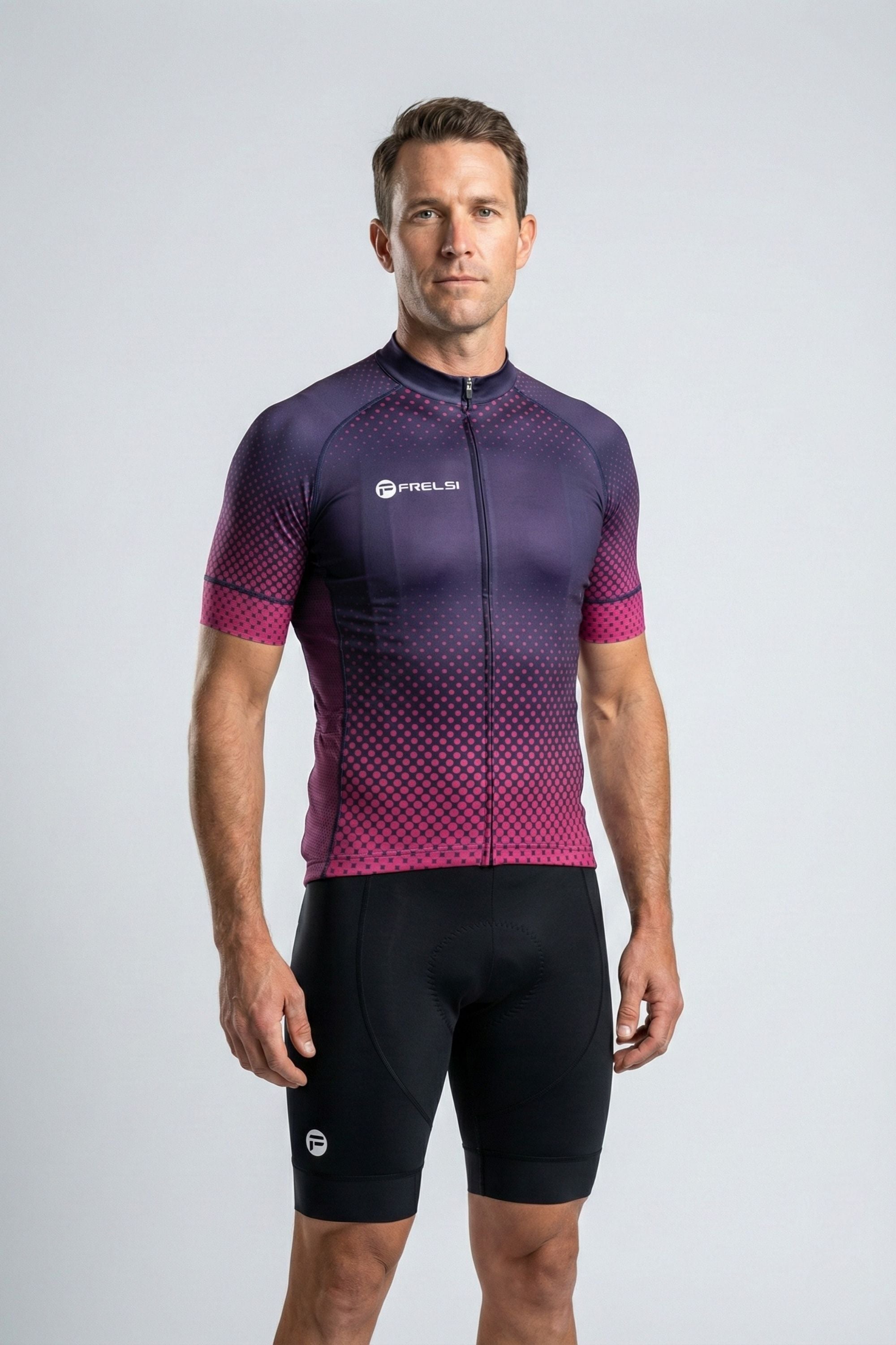 Man wearing a purple and pink cycling jersey with black shorts on a gray background