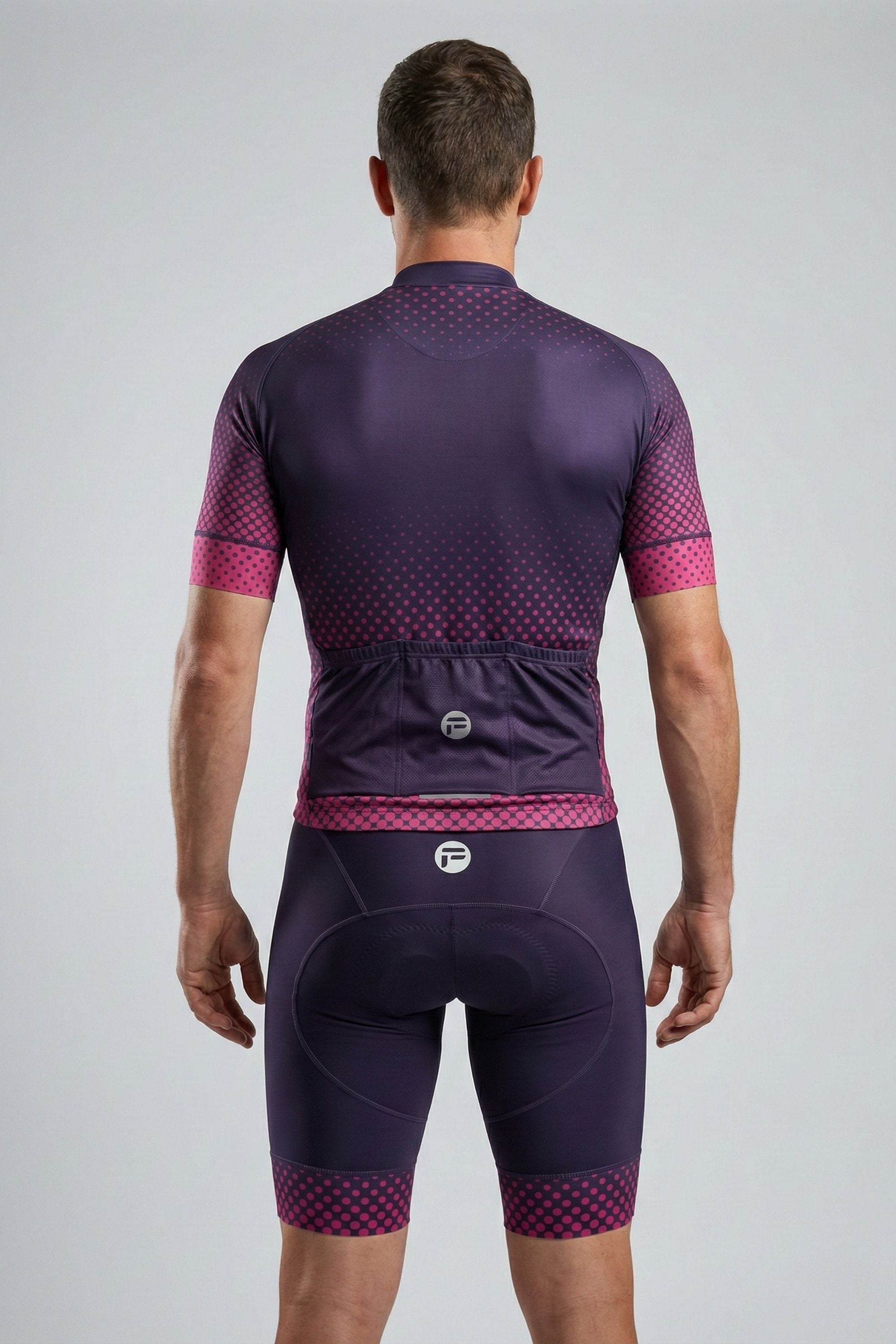 Person wearing a purple cycling outfit with pink accents on a gray background