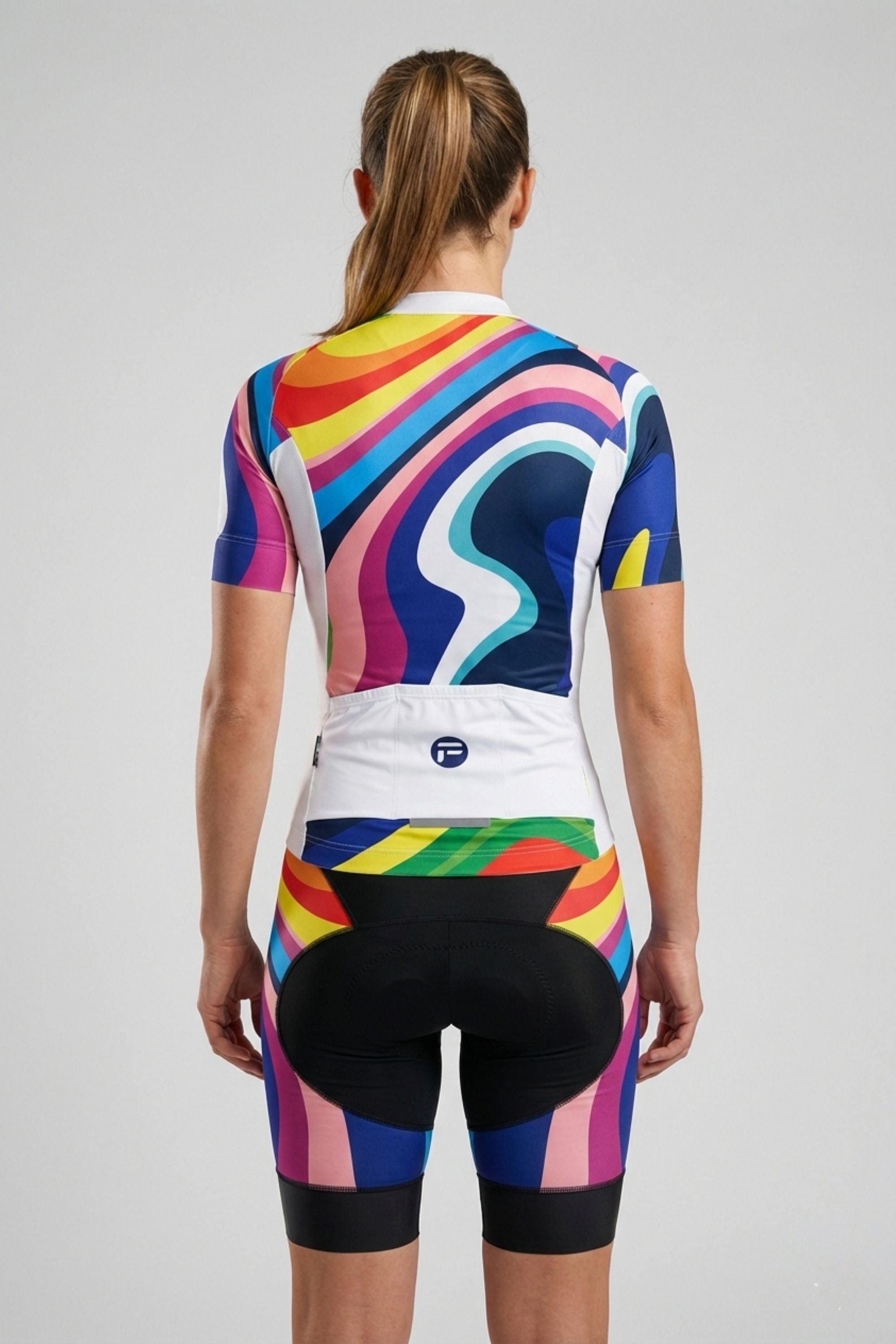 Person wearing a colorful cycling outfit on a plain background by Cycling Frelsi
