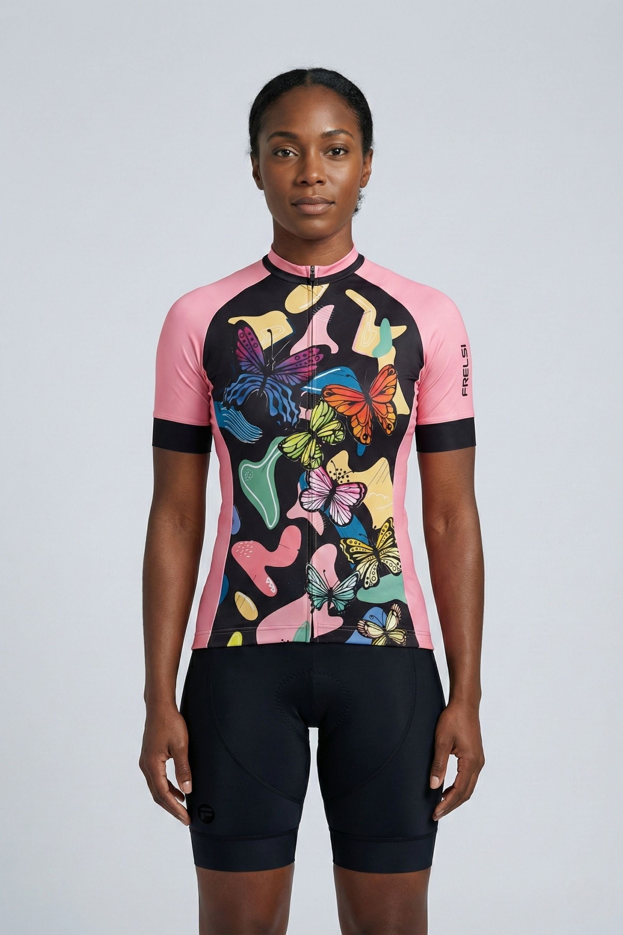 Person wearing a black and pink cycling outfit with butterflies on a plain background by Cycling Frelsi