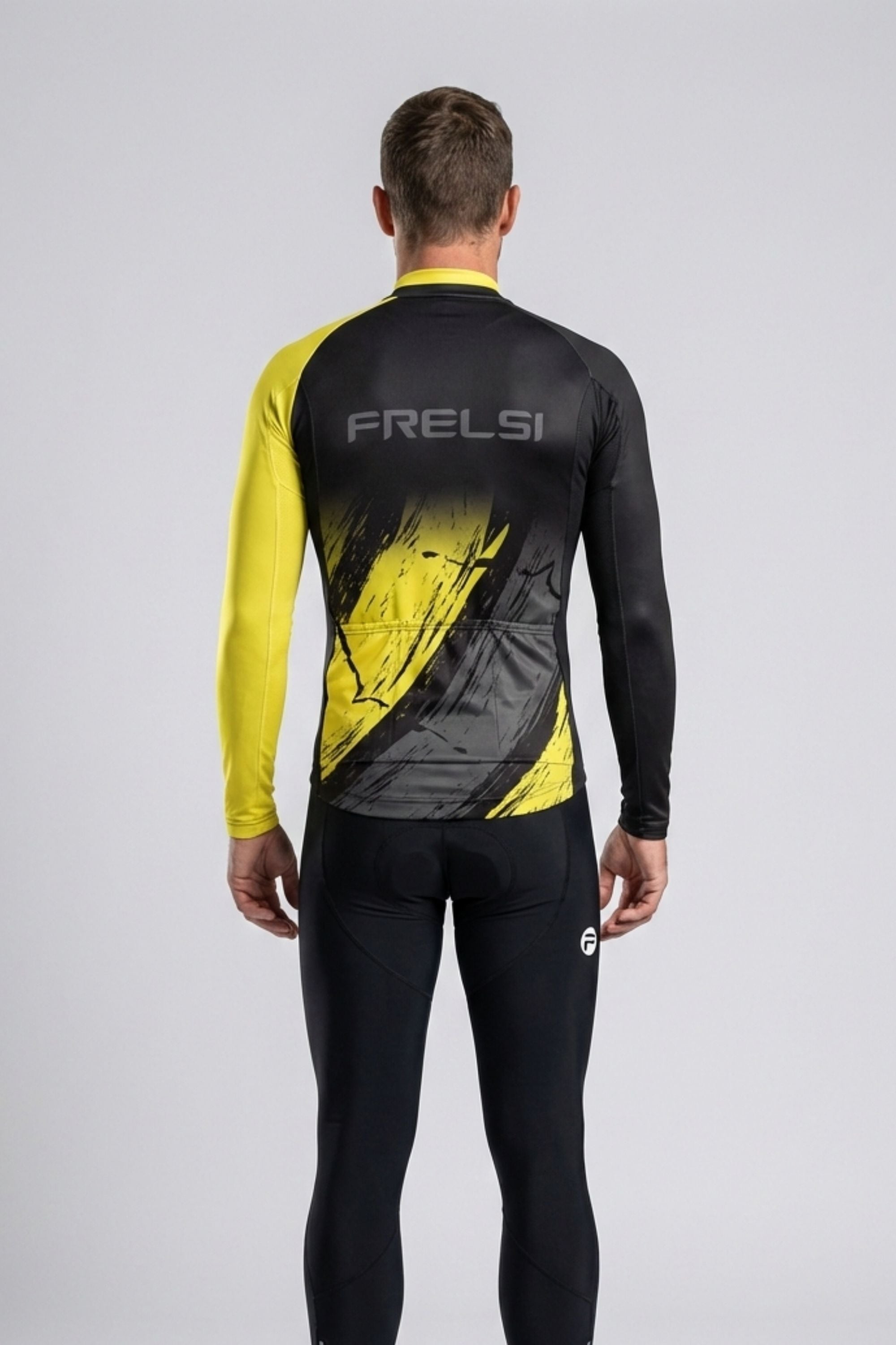 Person wearing a black and yellow cycling outfit with 'FRELSI' branding on the back.