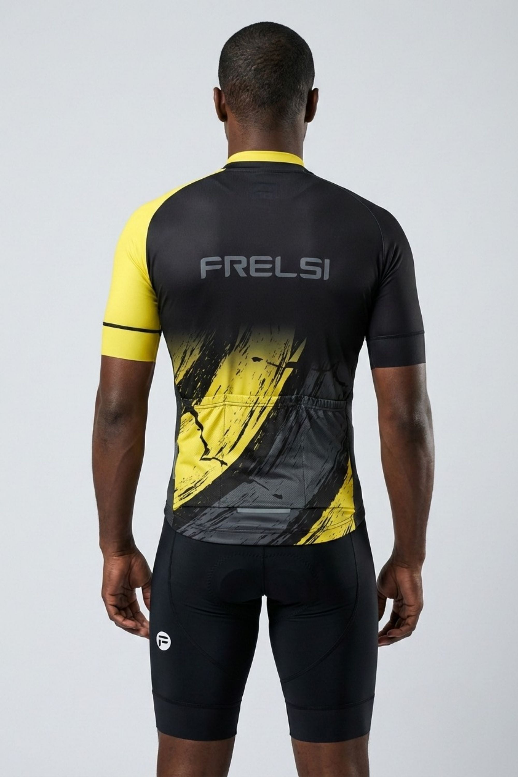 Person wearing a black and yellow cycling outfit with 'FRELSI' branding on the back.