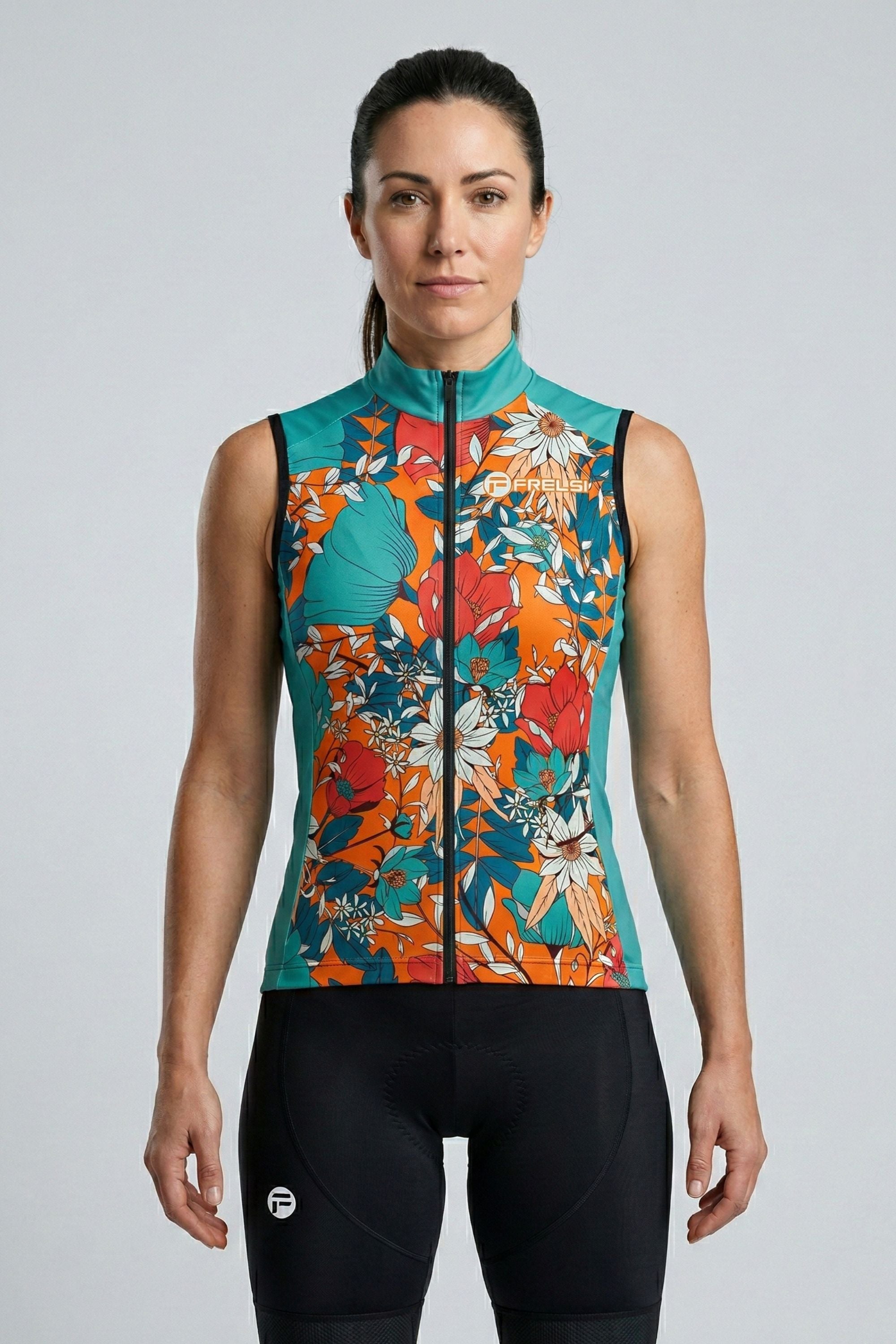 Woman wearing a colorful floral sleeveless jacket on a gray background