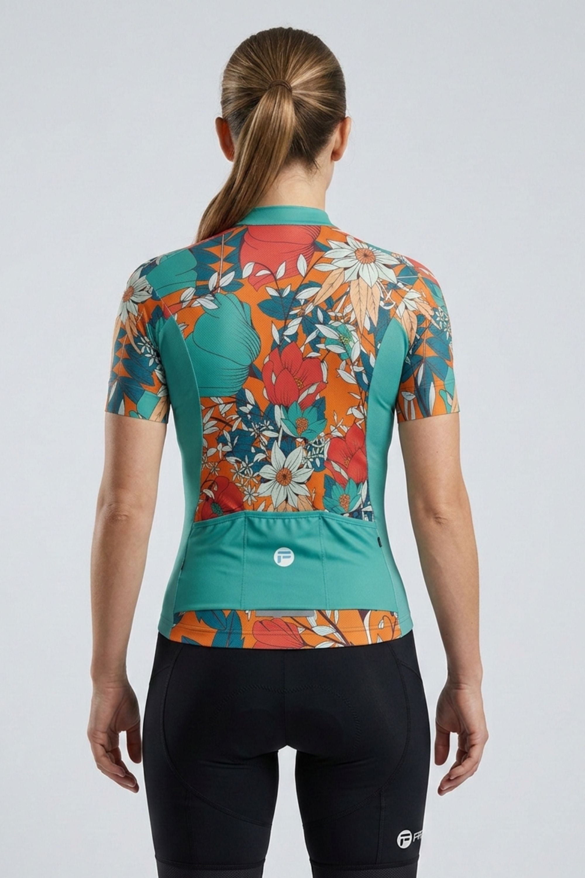 Woman wearing a colorful floral cycling jersey on a white background