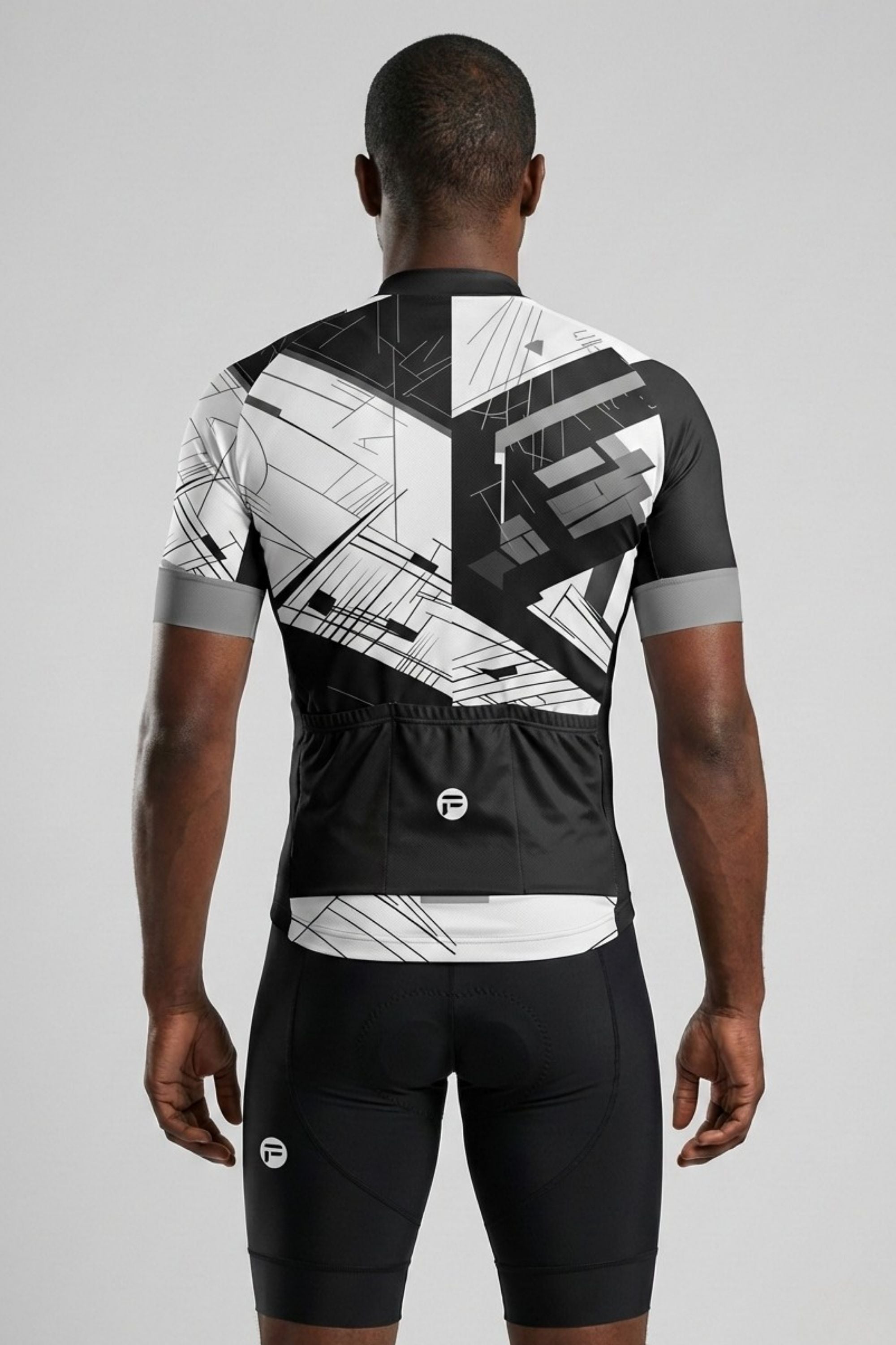 Person wearing a black and white cycling outfit with geometric patterns on a gray background