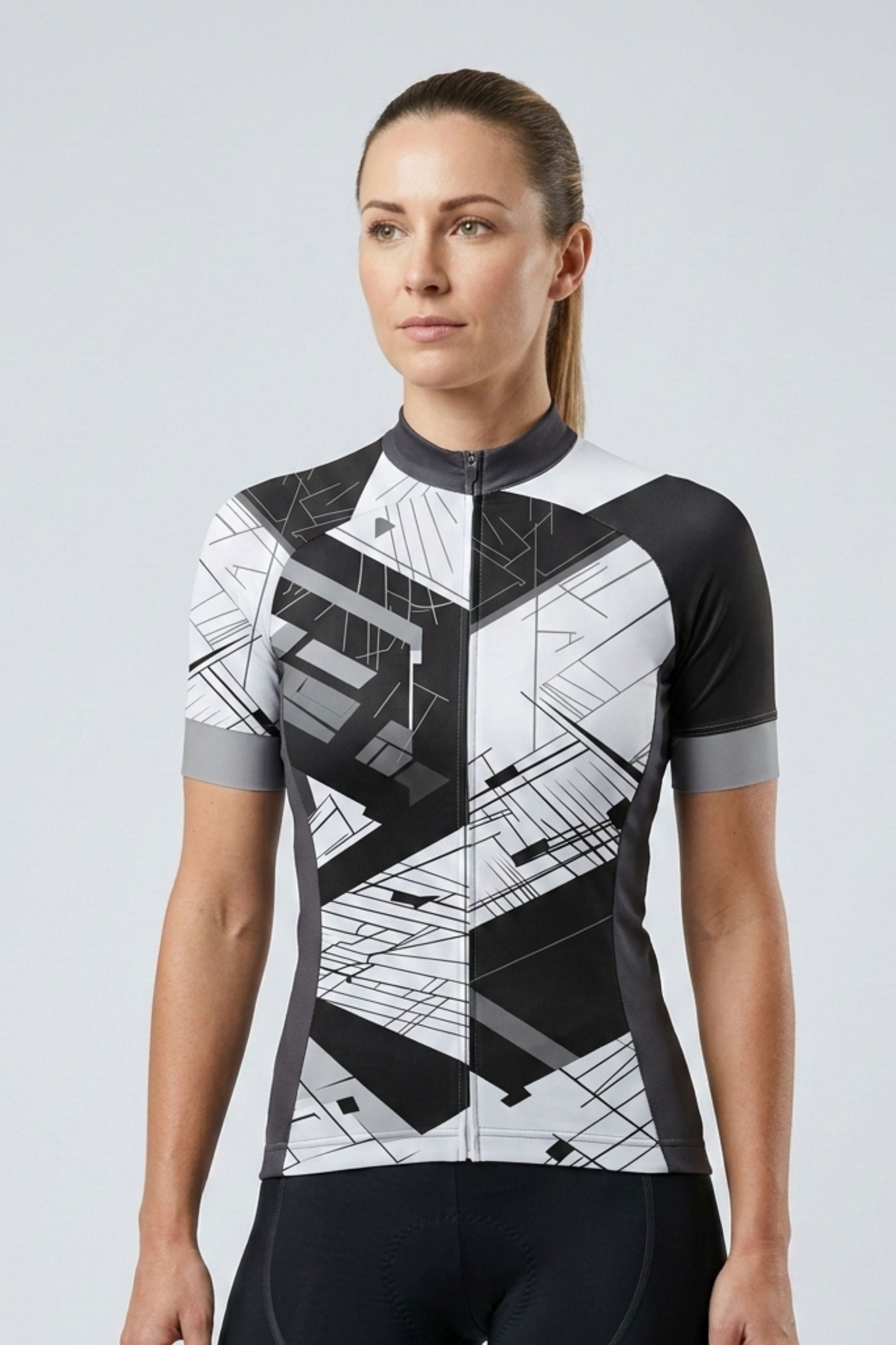 Woman wearing a black and white geometric patterned cycling jersey on a light gray background