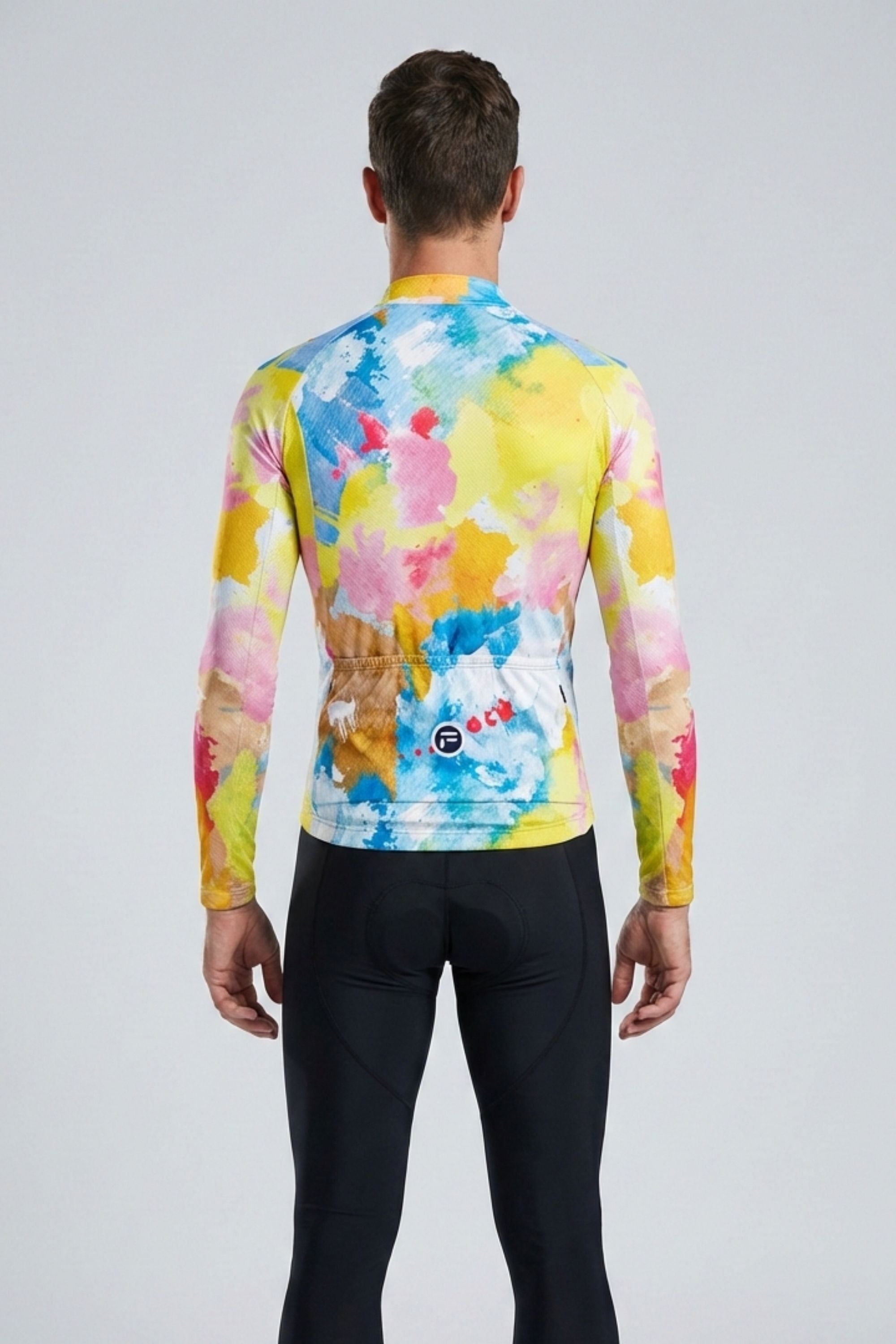 Person wearing a colorful long-sleeve shirt with a watercolor design on a plain background
