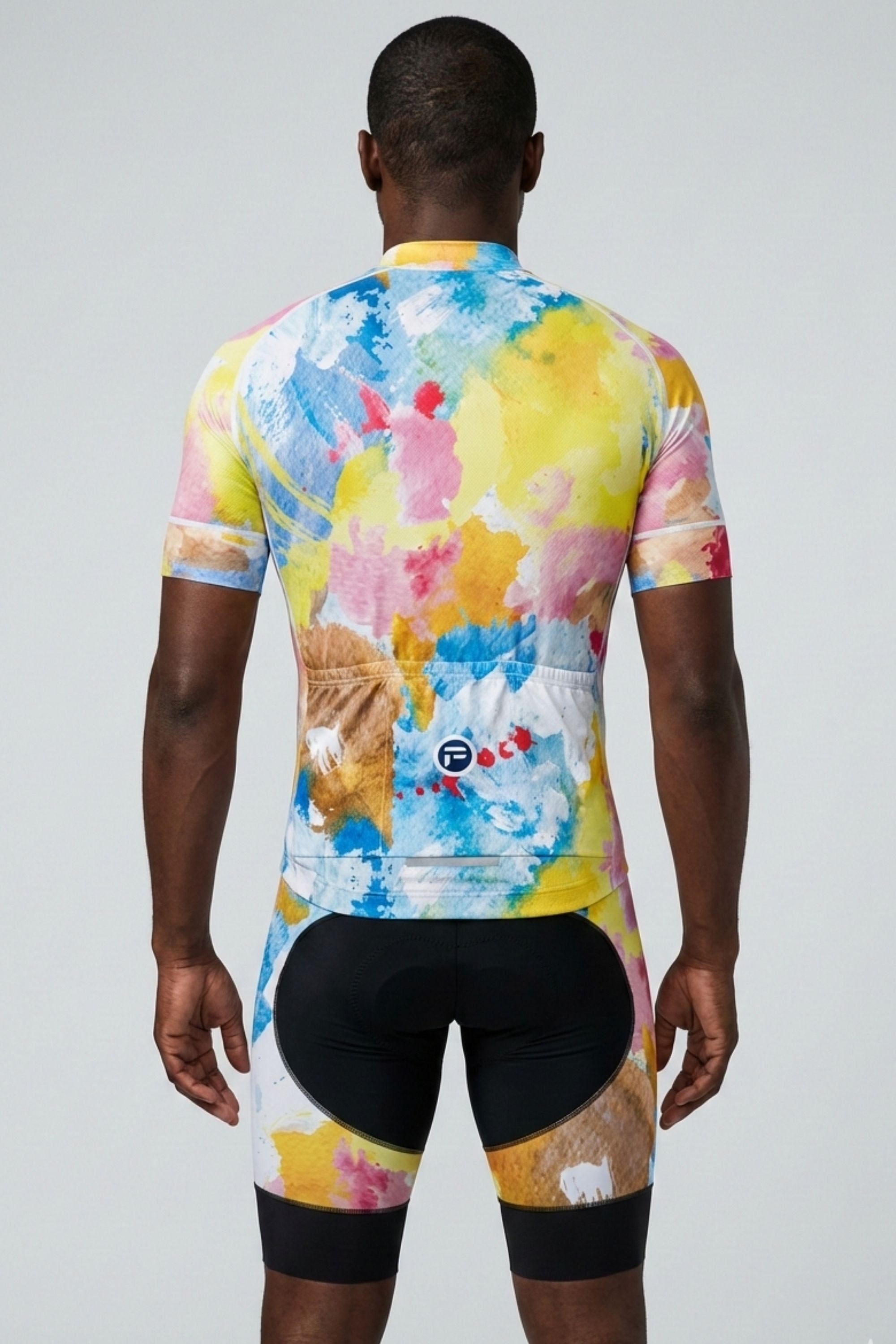 Person wearing a colorful cycling jersey and shorts on a plain background