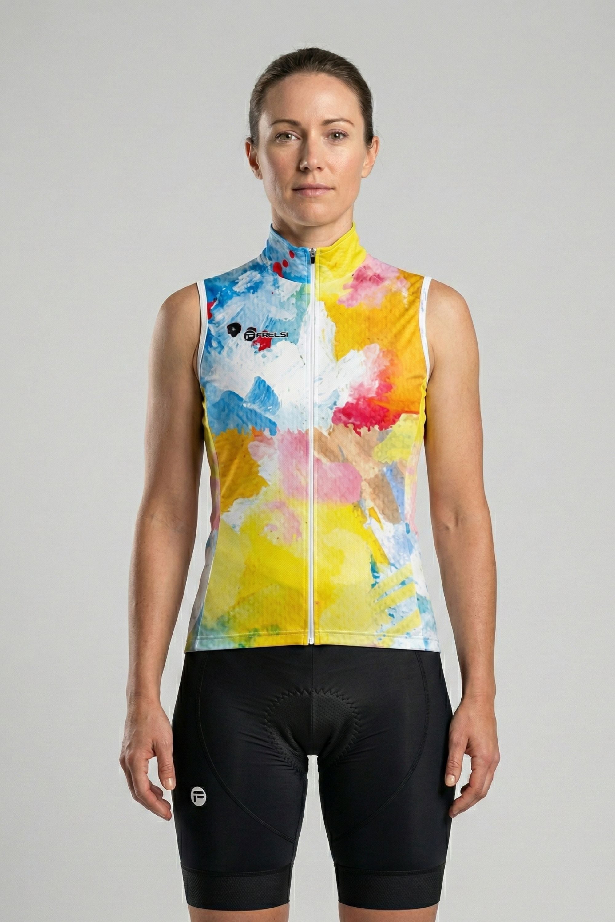 Woman wearing a colorful cycling vest and black shorts on a gray background