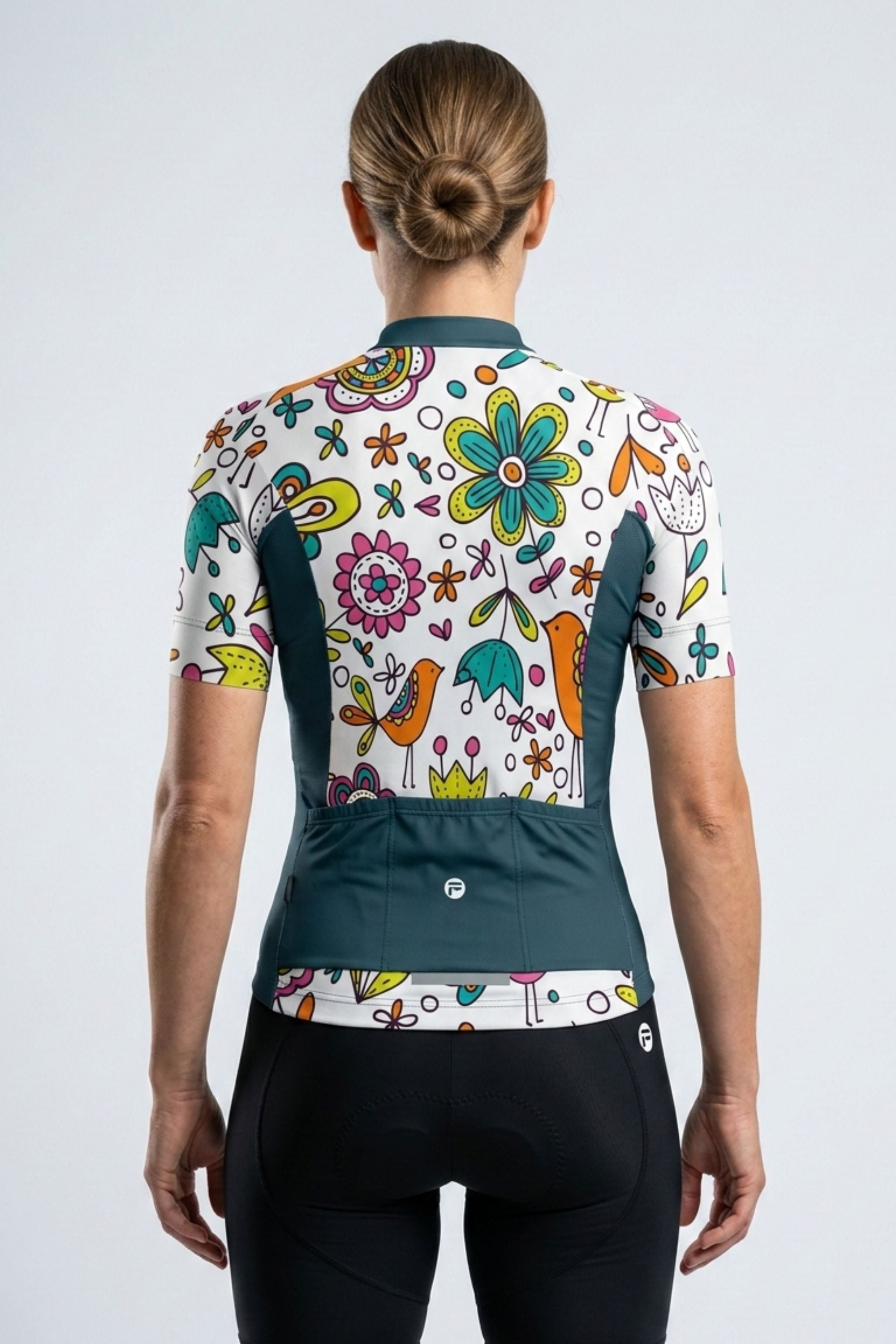 Person wearing a colorful cycling jersey with floral and abstract designs on a white background