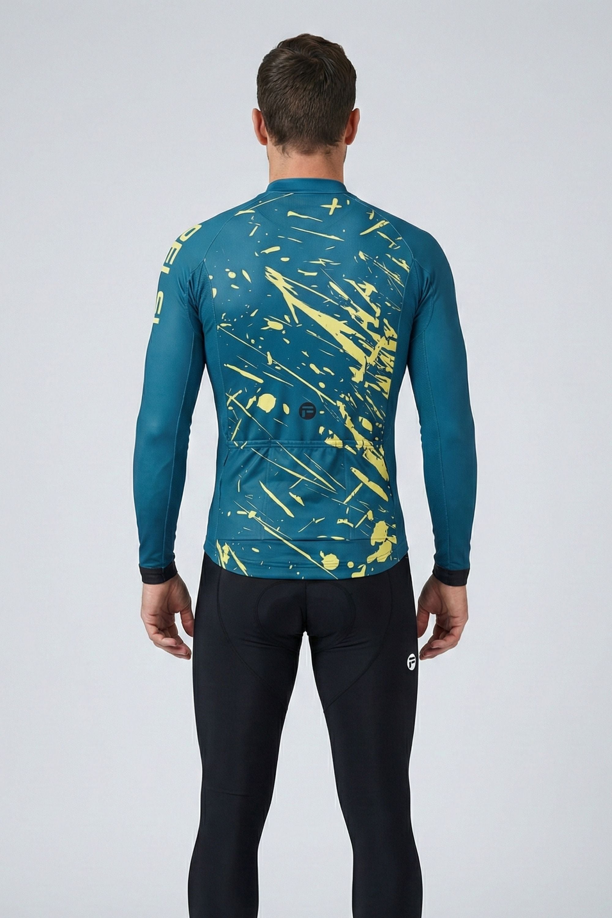 Person wearing a teal and yellow long-sleeve top with black pants on a white background