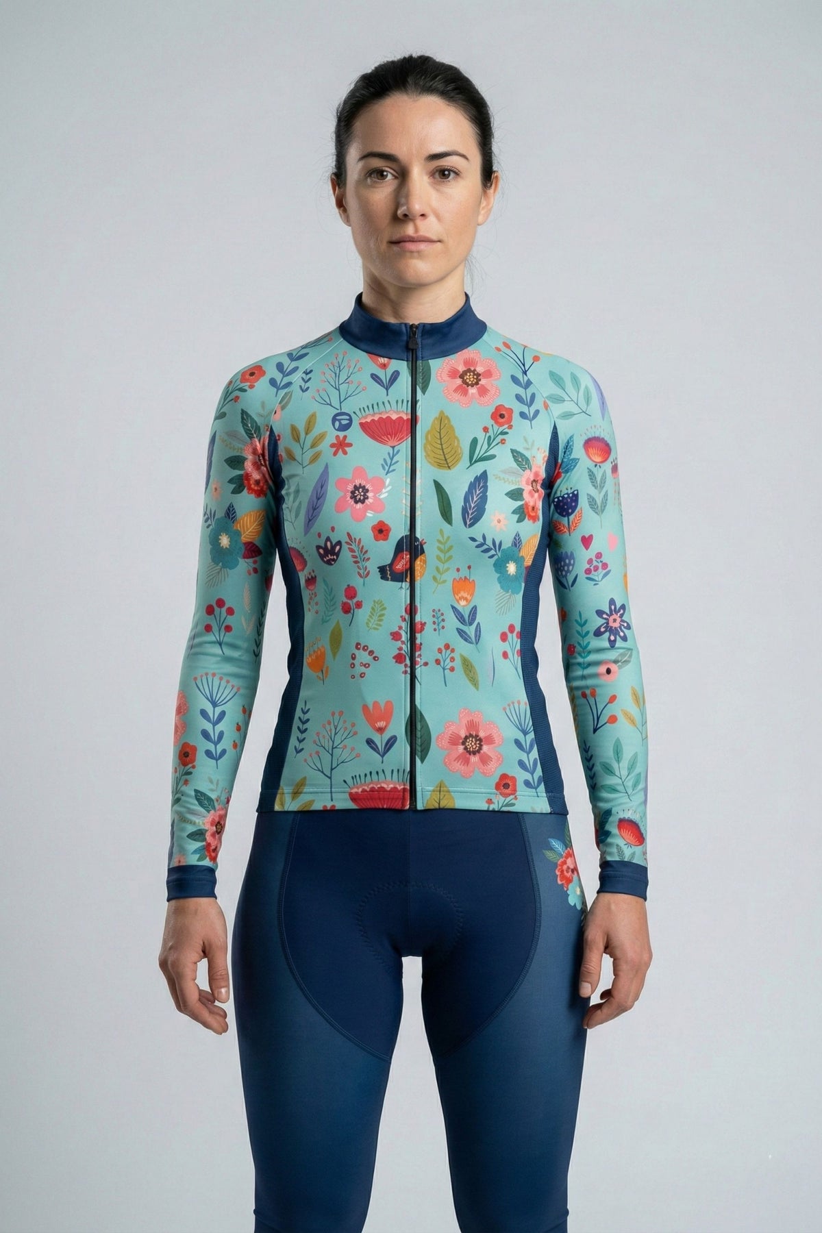 Person wearing a blue cycling set with flowers accents by Cycling Frelsi on a gray background