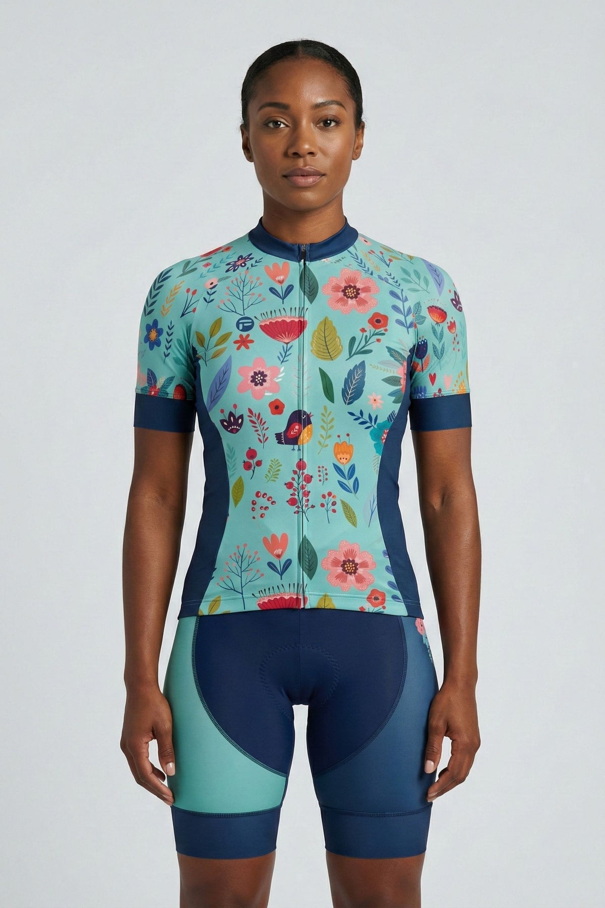 Person wearing a blue cycling outfit with flowers on a plain background by Cycling Frelsi 