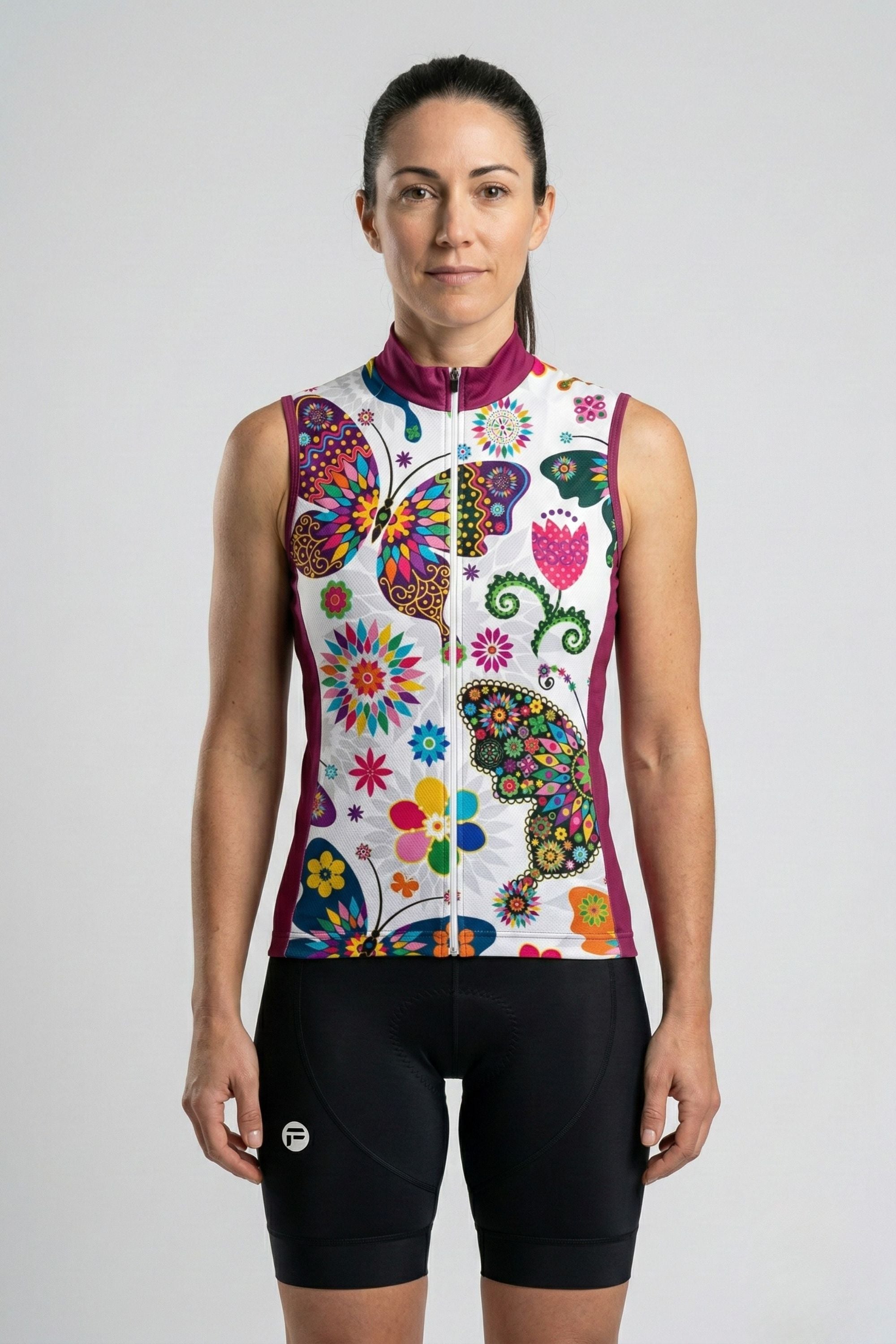 Woman wearing a colorful butterfly-patterned sleeveless cycling outfit on a white background