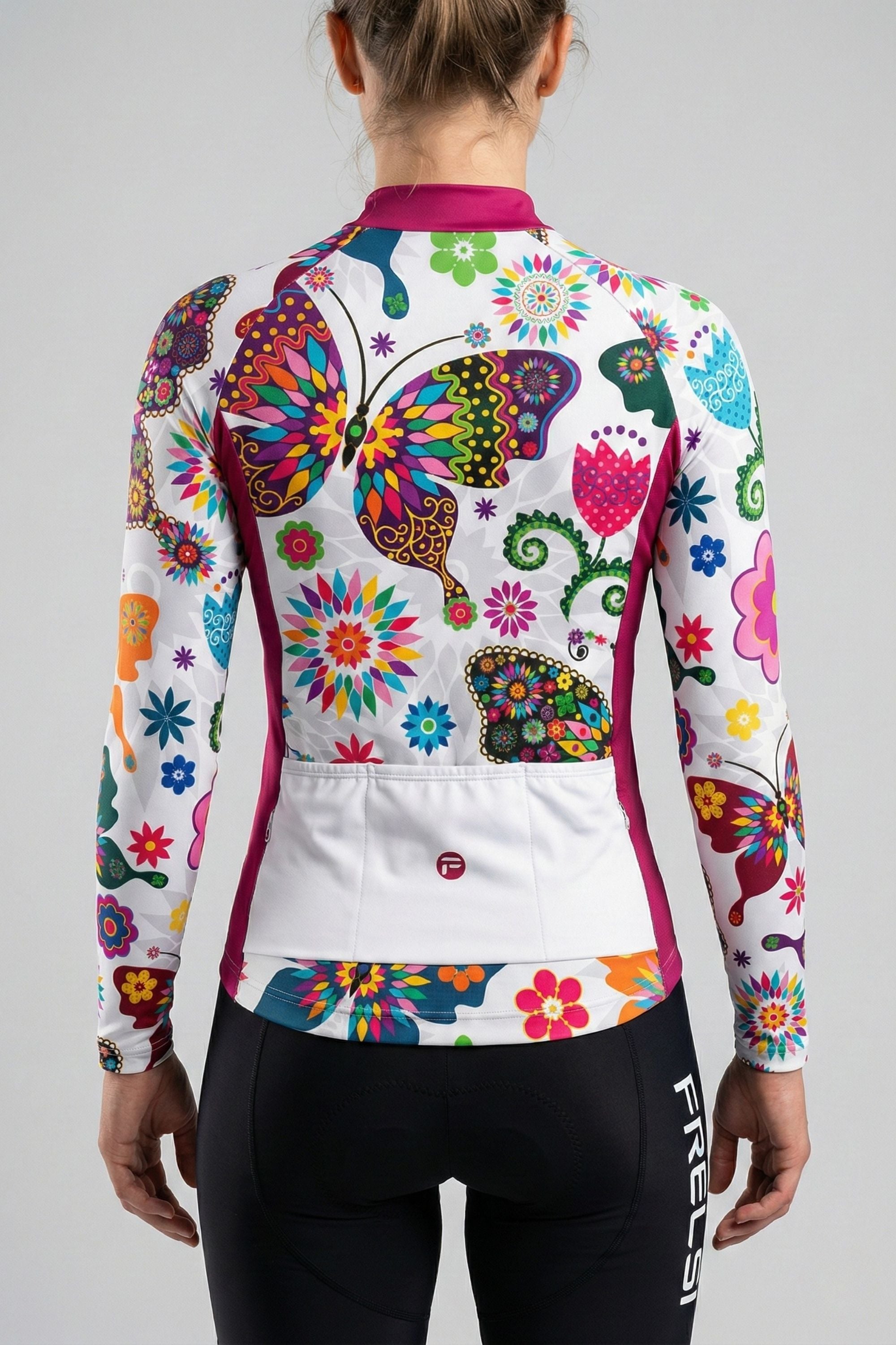 Person wearing a white cycling jersey with colorful butterfly accents by Cycling Frelsi on a gray background