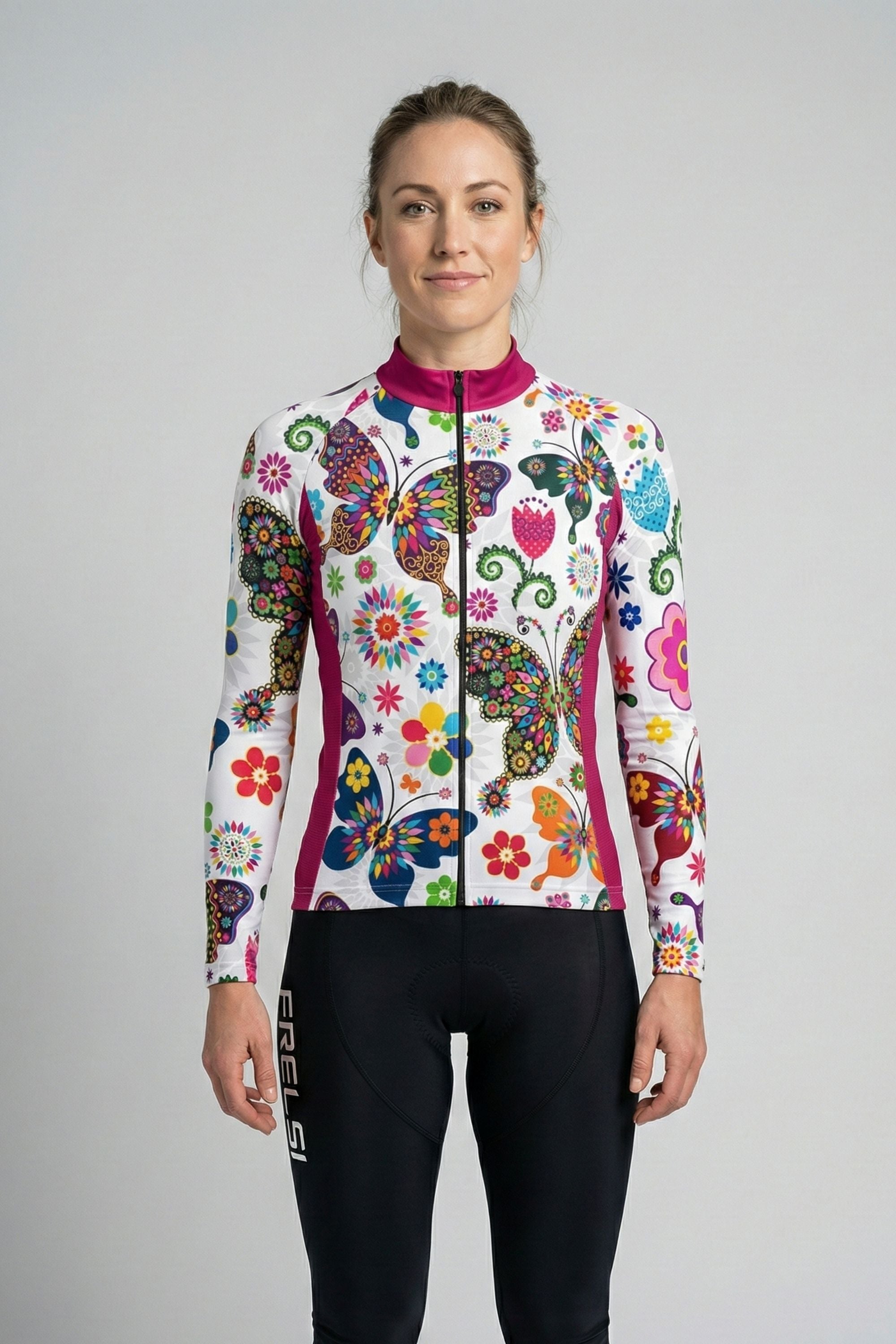 Person wearing a white cycling jersey with colorful butterfly accents by Cycling Frelsi on a gray background