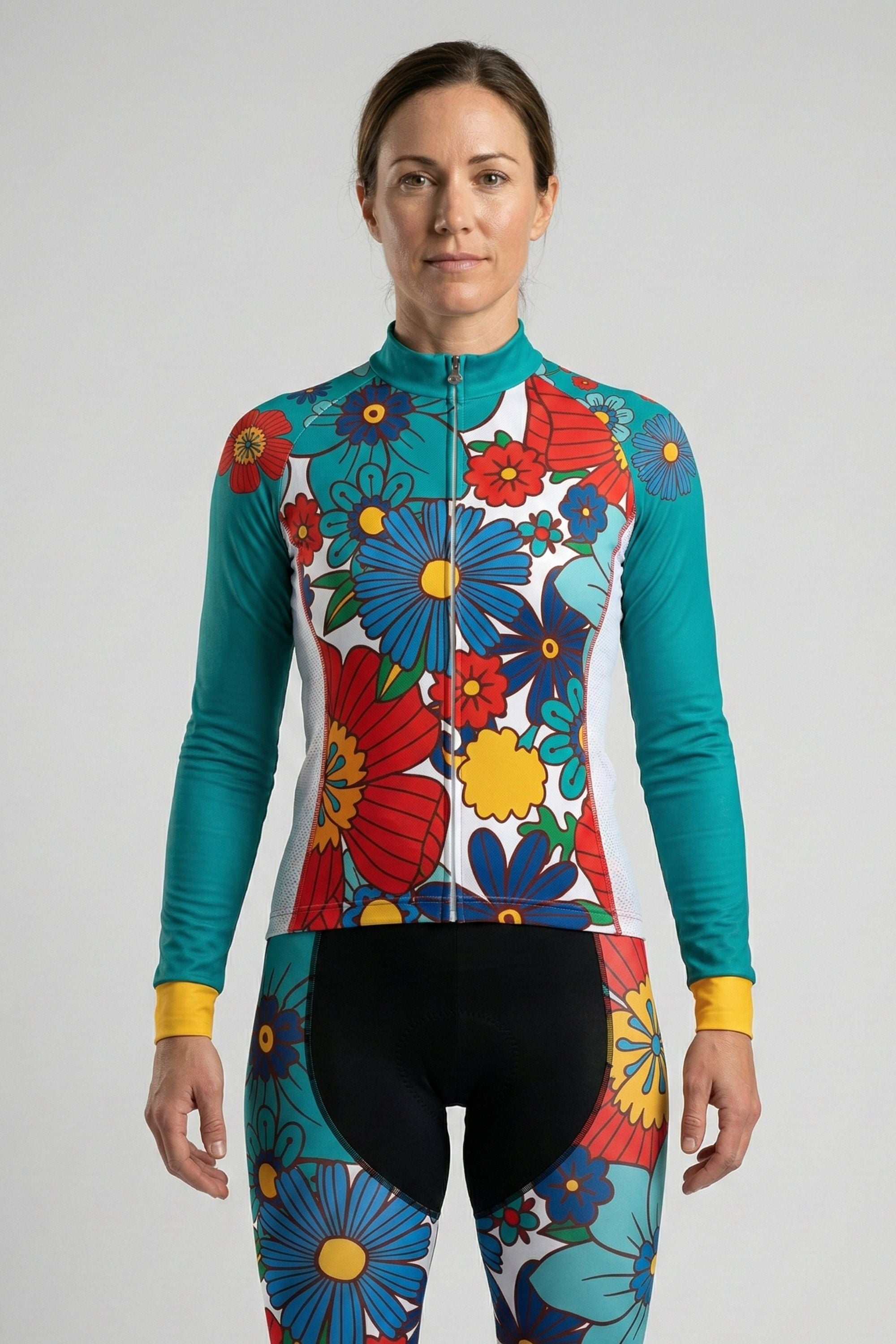 Woman wearing a colorful floral cycling outfit on a plain background