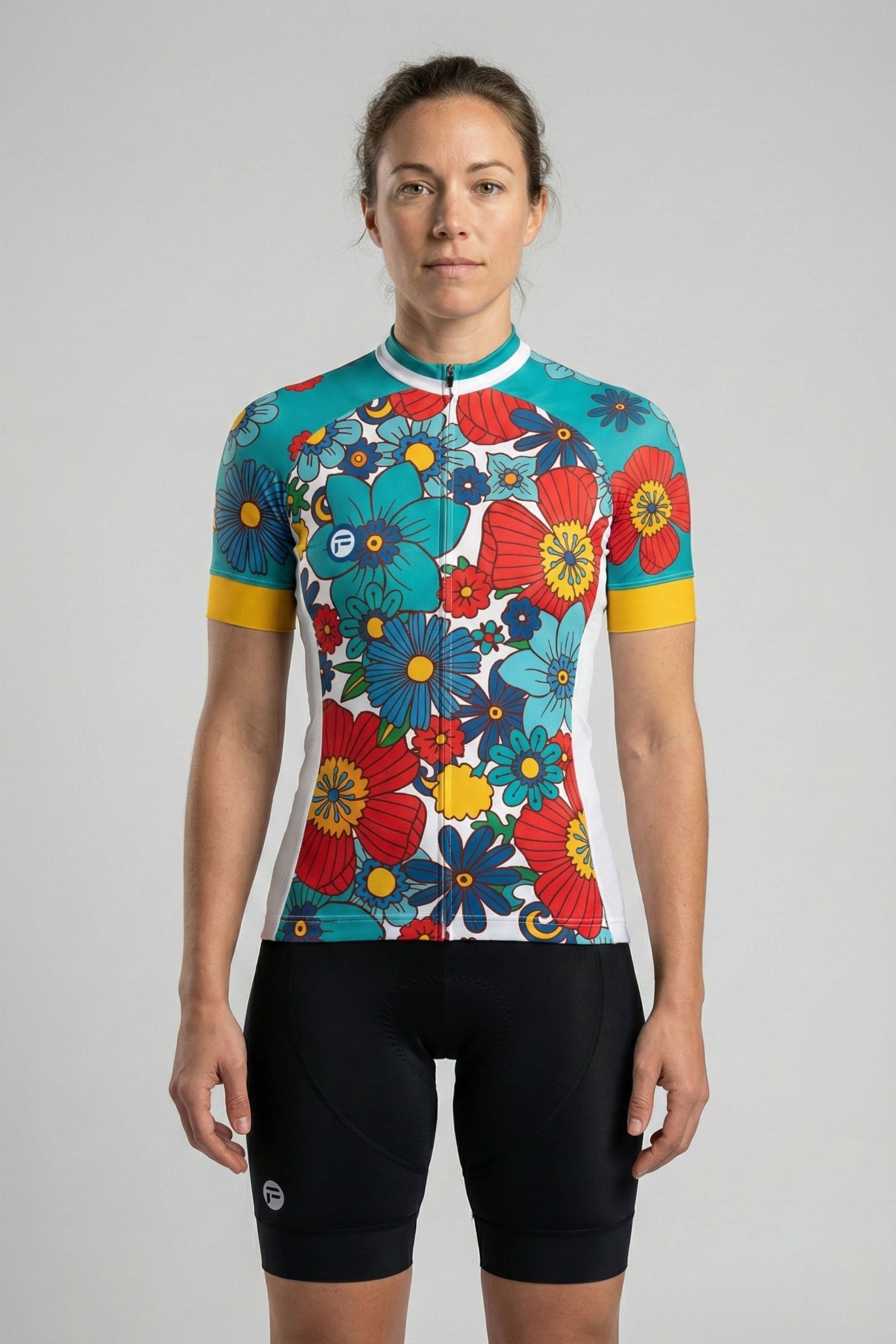 Person wearing a cycling jersey with colorful flowers accents by Cycling Frelsi on a gray background