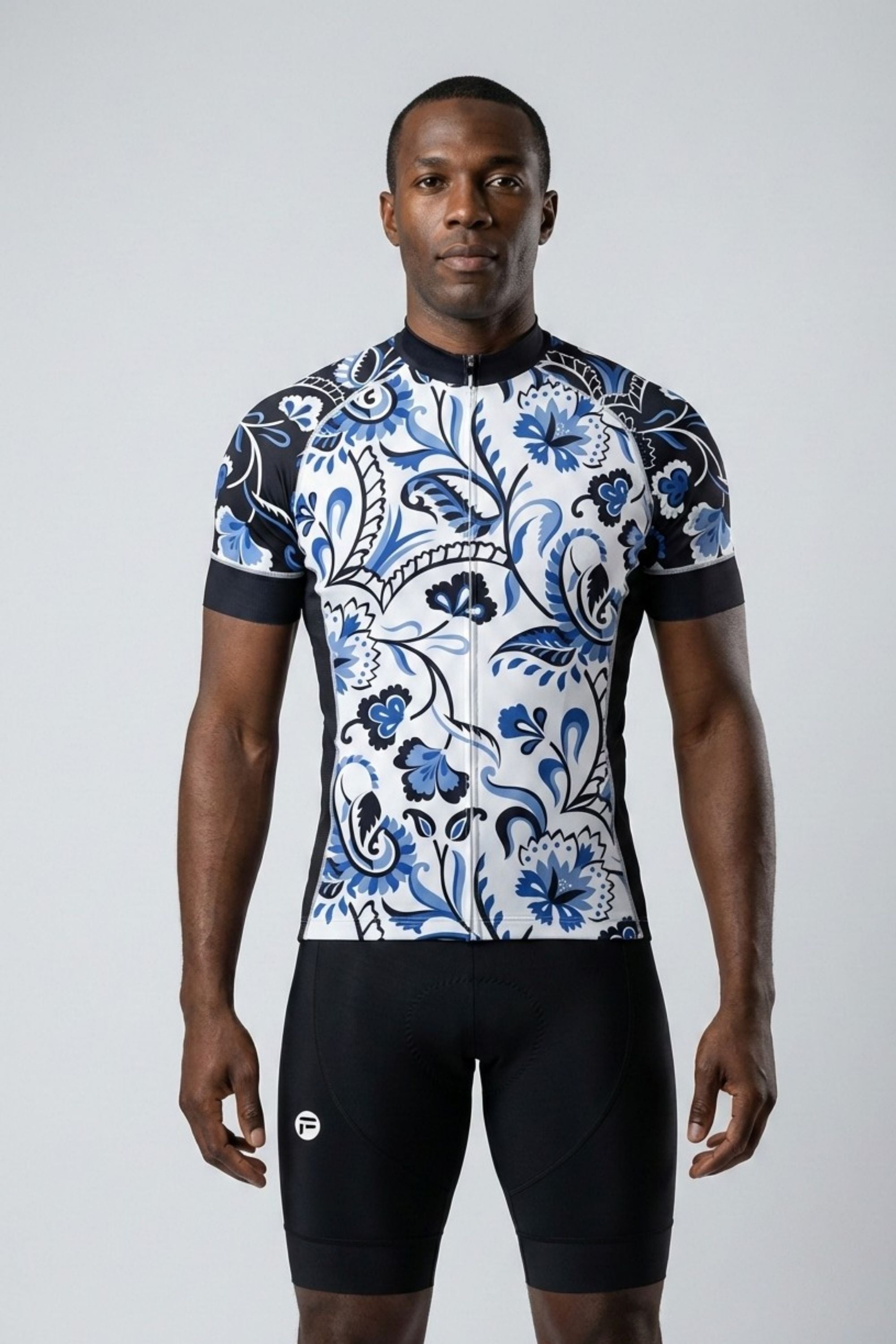 Person wearing a blue and white patterned cycling jersey and black shorts on a gray background