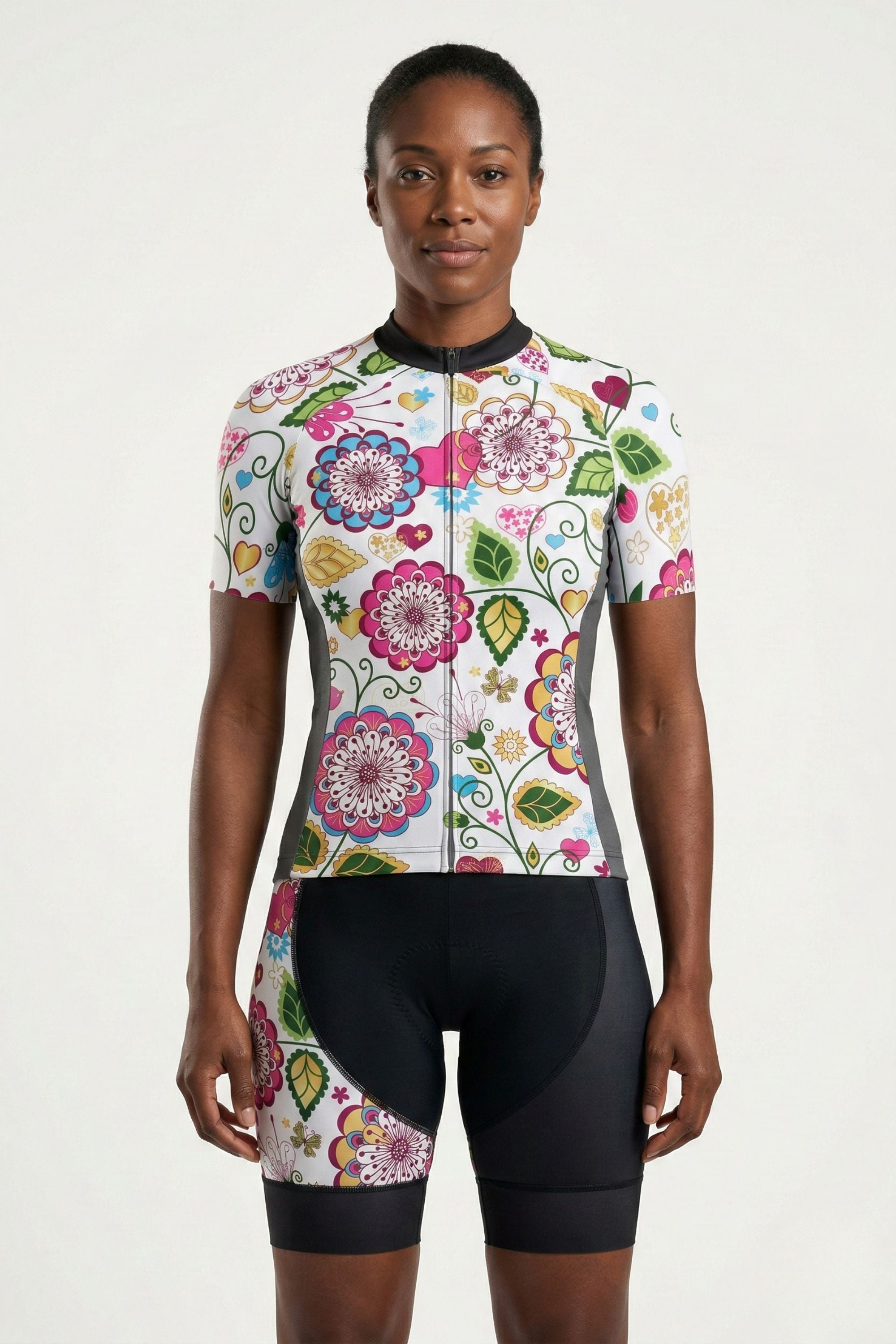 Woman wearing a colorful floral cycling outfit on a white background