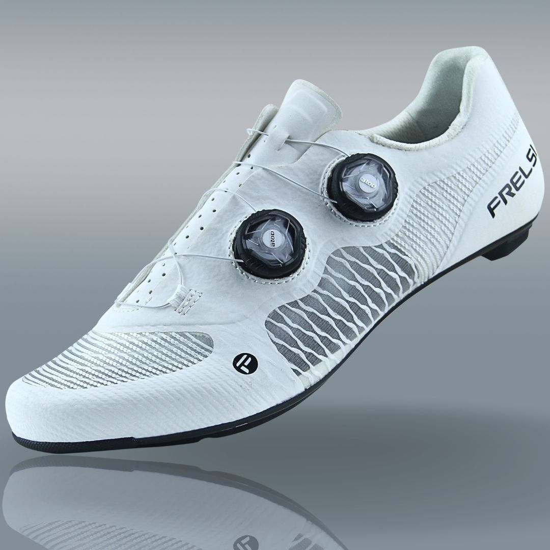 White Frelsi Pro Team carbon cycling shoes with aerodynamic design, breathable mesh, and dual Atop Dial closure.