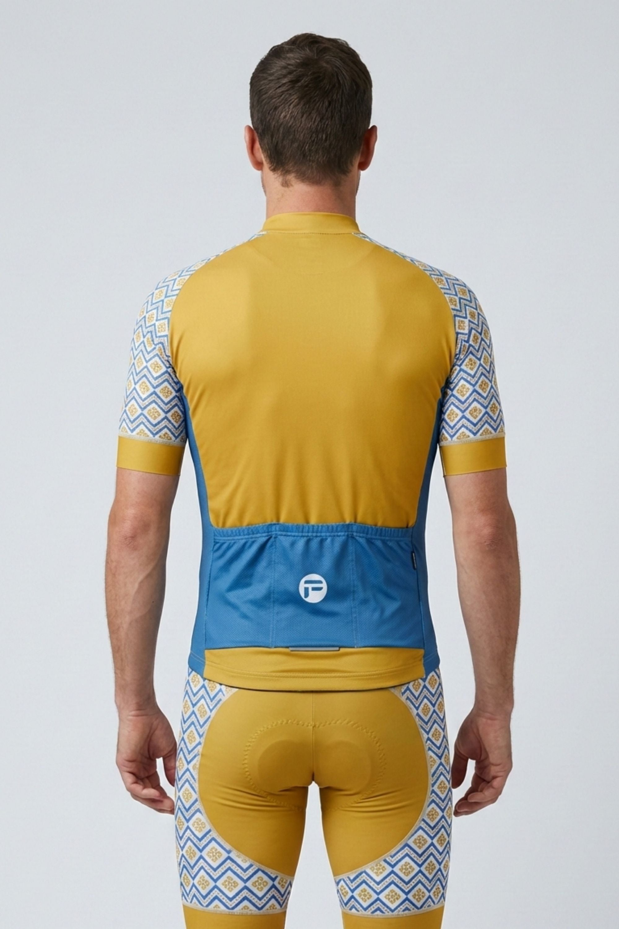 Cyclist wearing a yellow and blue cycling outfit with geometric patterns on a white background
