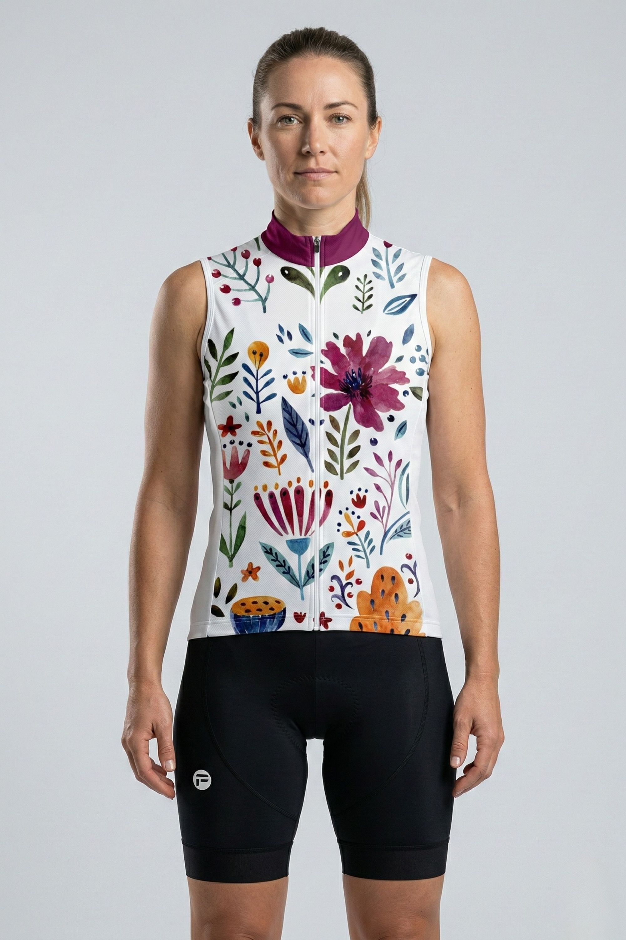 Woman wearing a sleeveless cycling jersey with floral design on a plain background